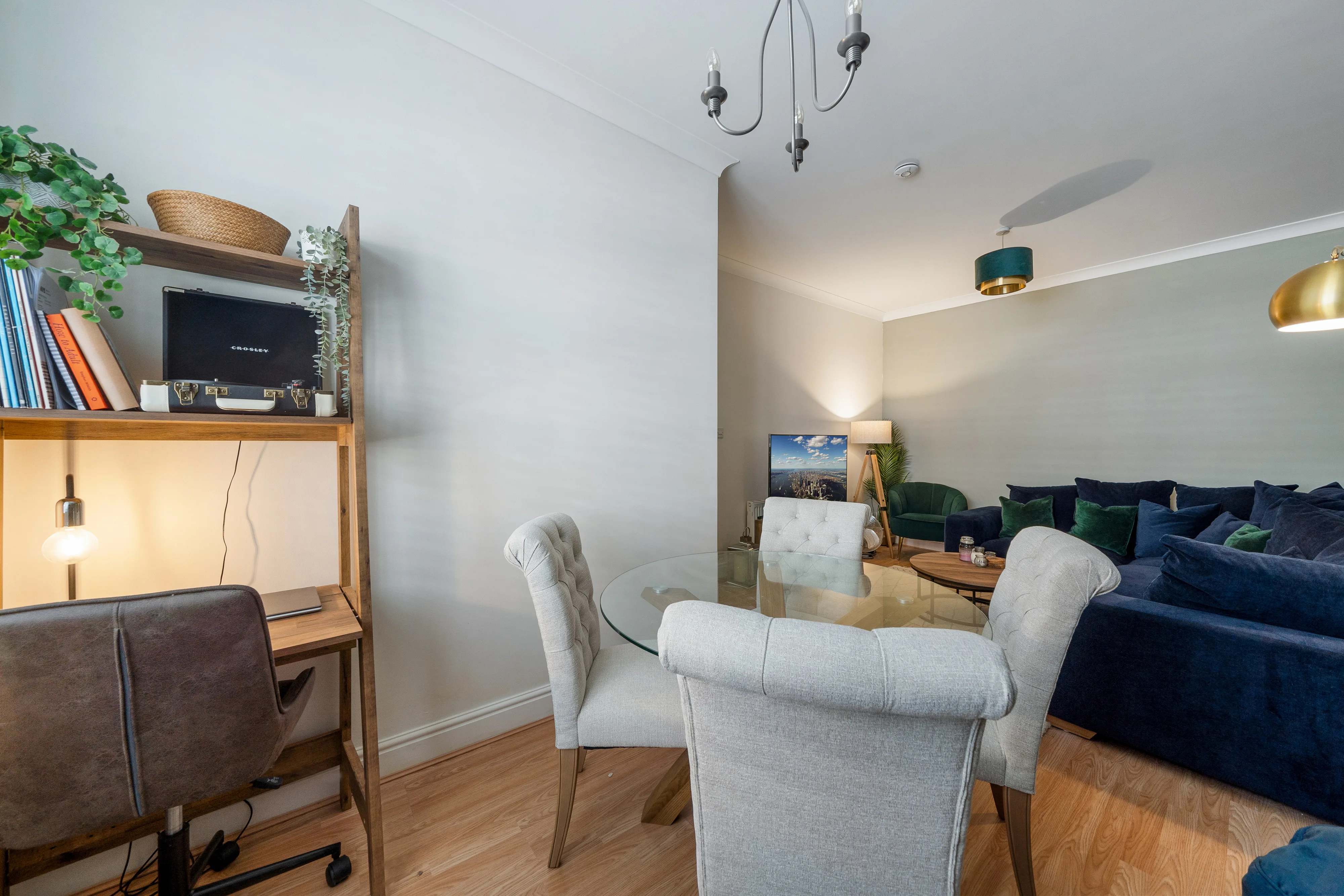 Reception and dining room with a navy sofa, table and large window