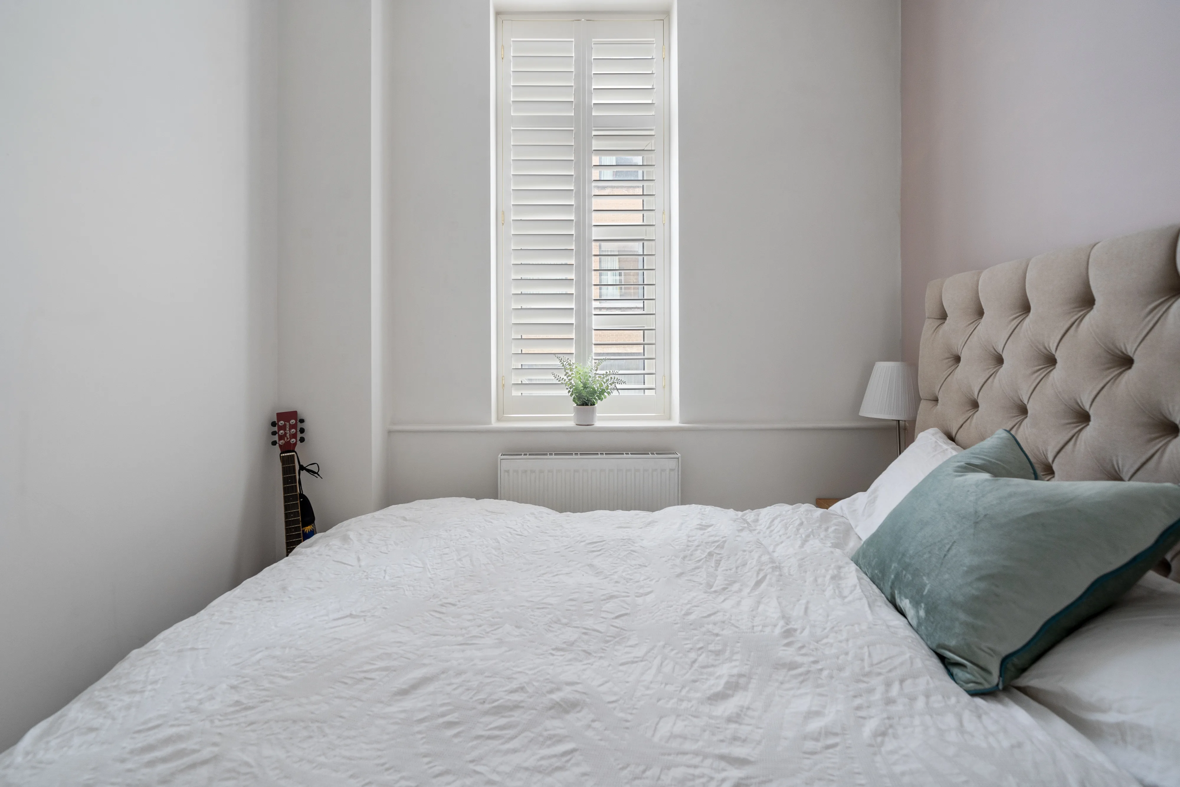 Bedroom with a double bed, dressing table and shuttered window