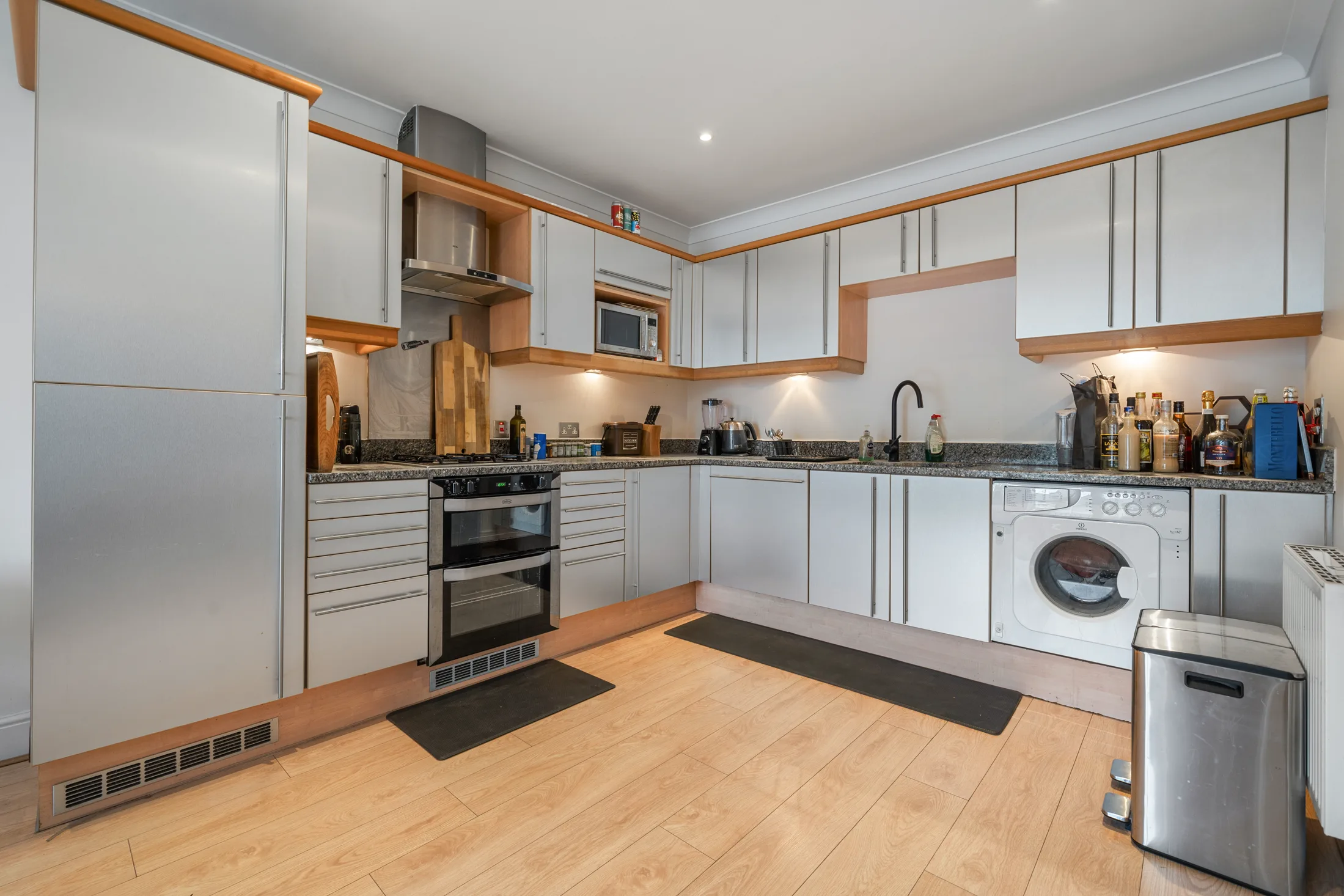 Fitted kitchen with white cabinetry and integrated appliances