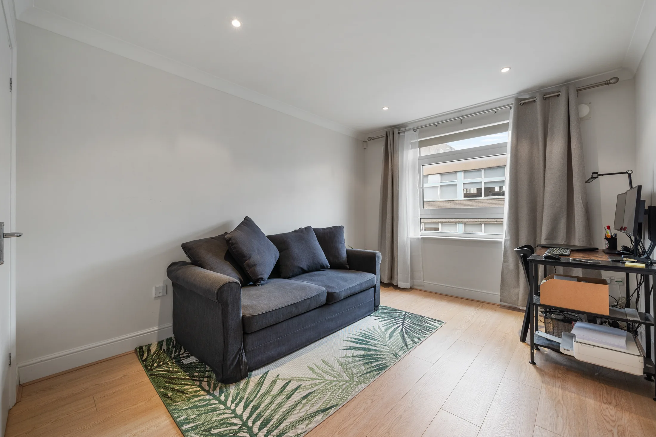 Reception room with a sofa, television and large window