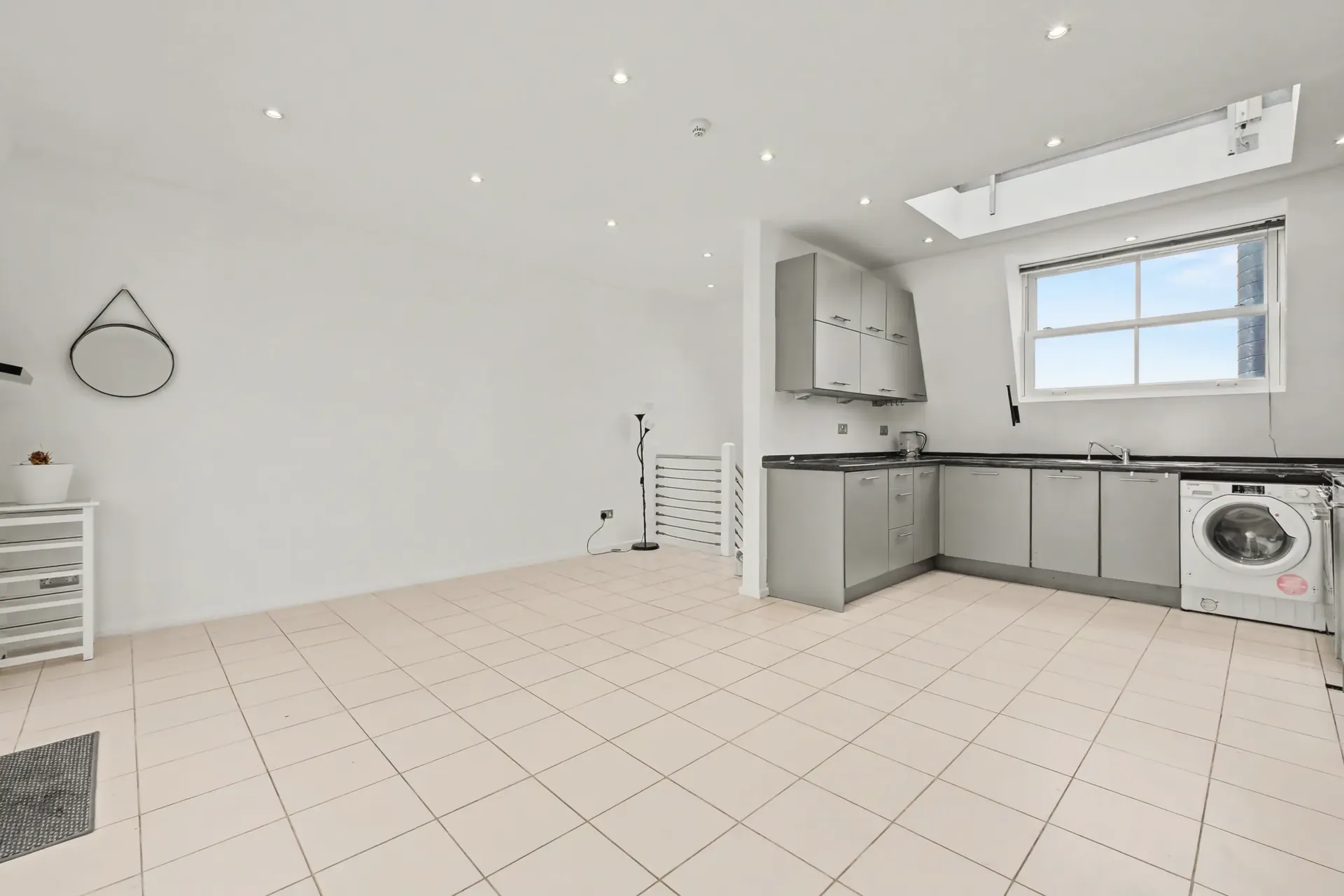 Open-plan reception room and kitchen with a skylight and tiled flooring