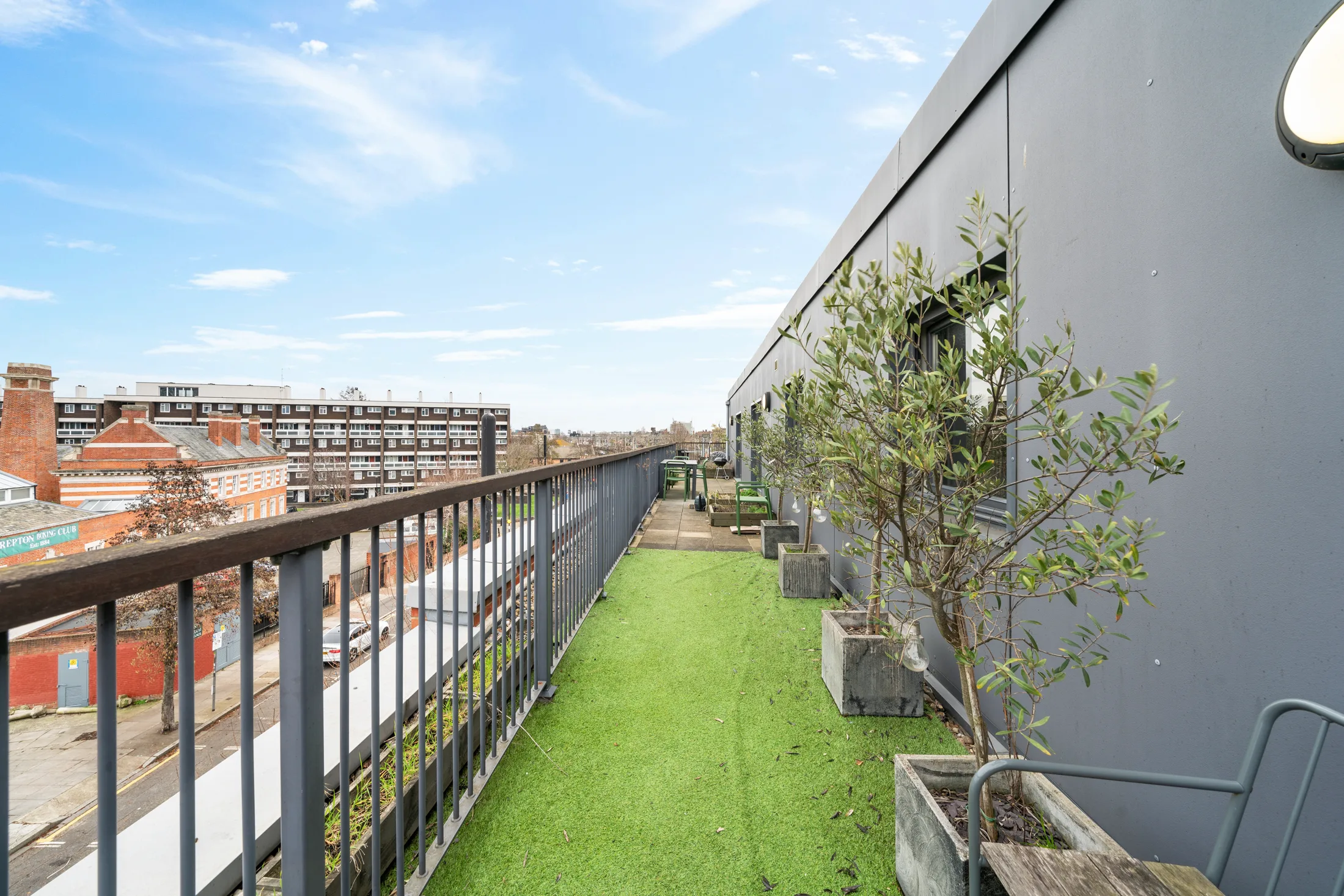 Private terrace with artificial lawn and planted containers
