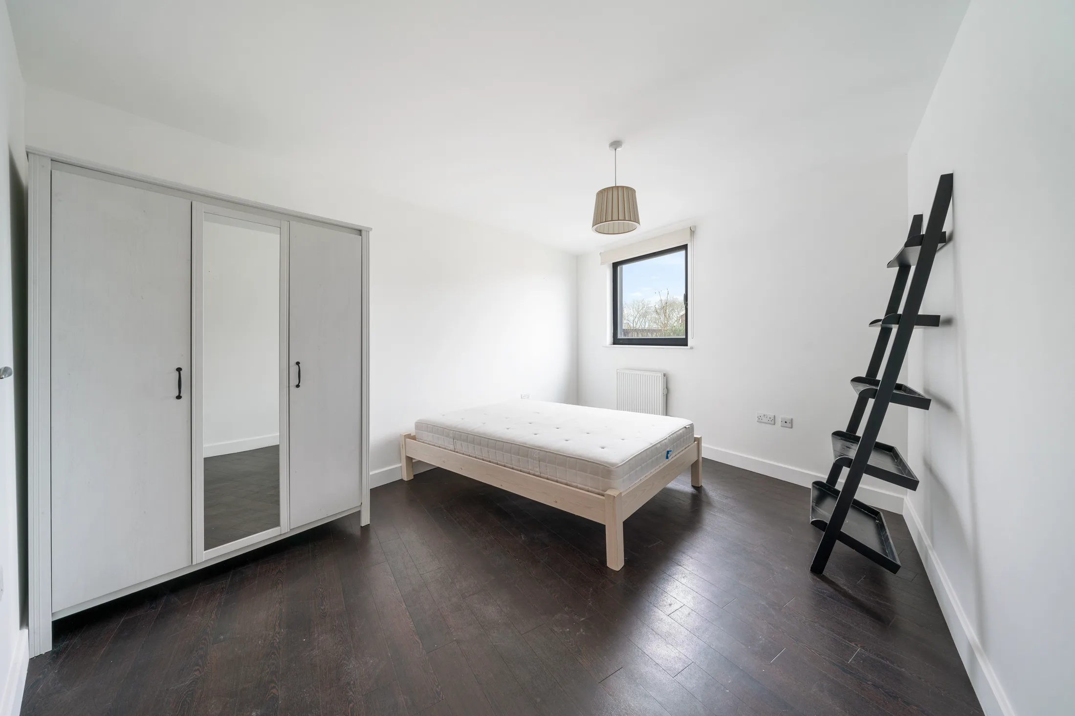 Bedroom with a wardrobe, double bed and ladder-style shelving