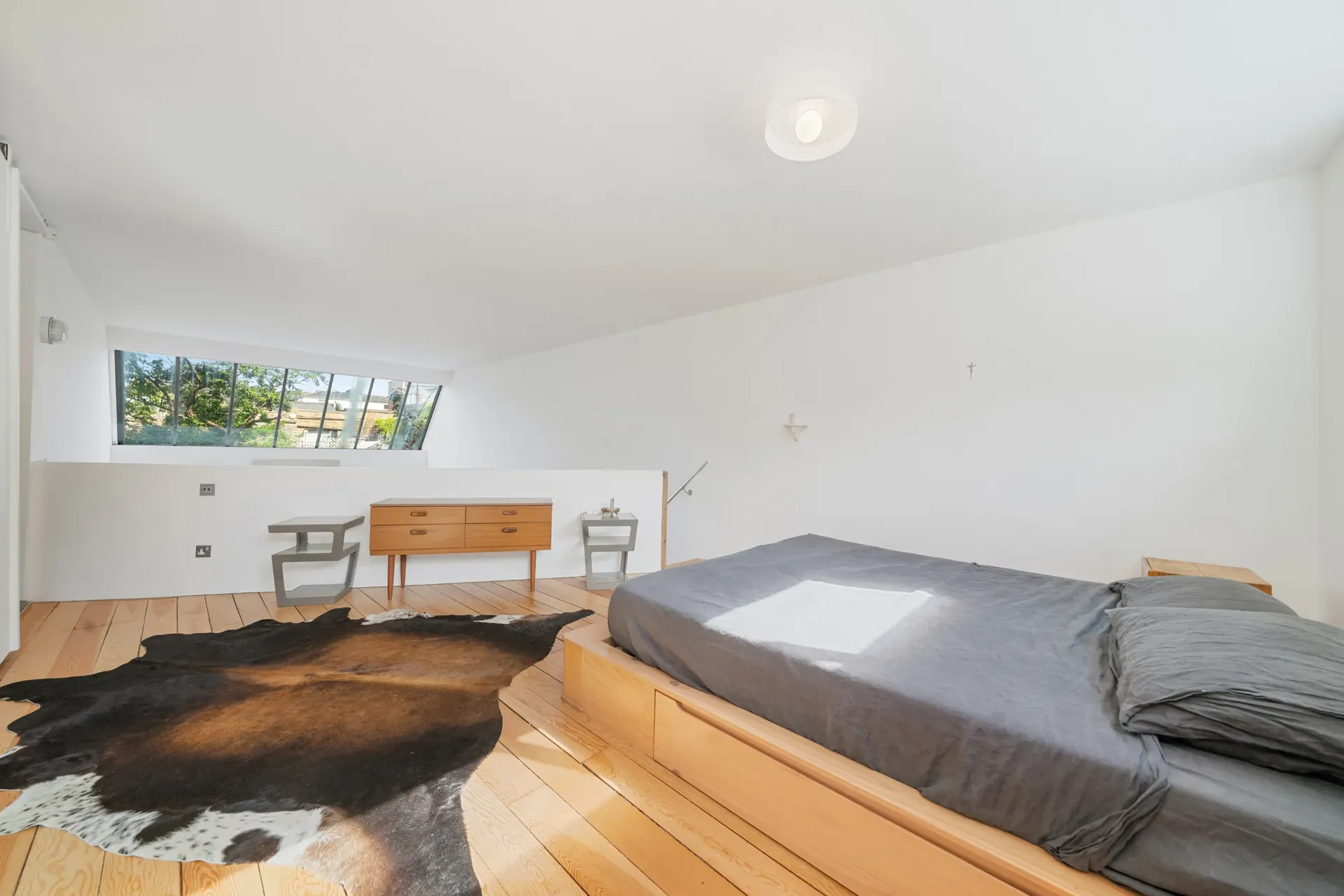Mezzanine bedroom overlooking the living room, with clerestory windows