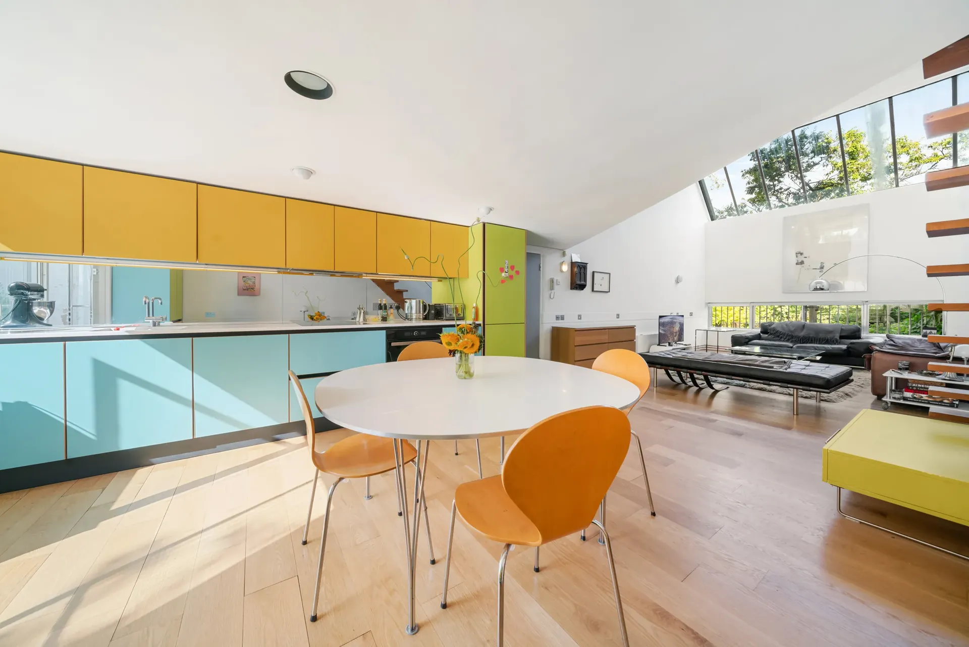Open-plan kitchen, dining and living space under the double-height ceiling