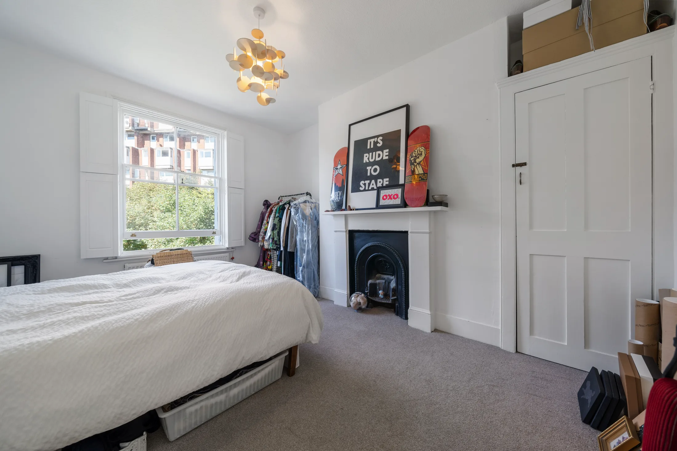 Bedroom with a white bed, fireplace and built-in wardrobe