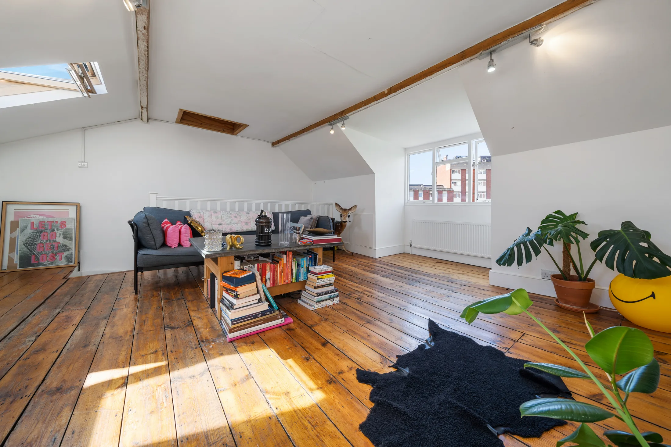 Top-floor reception room with timber flooring, skylights and plants