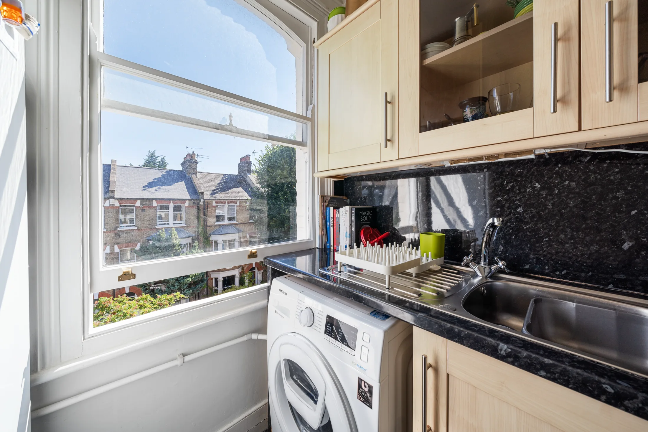Fitted kitchen with black worktops and window