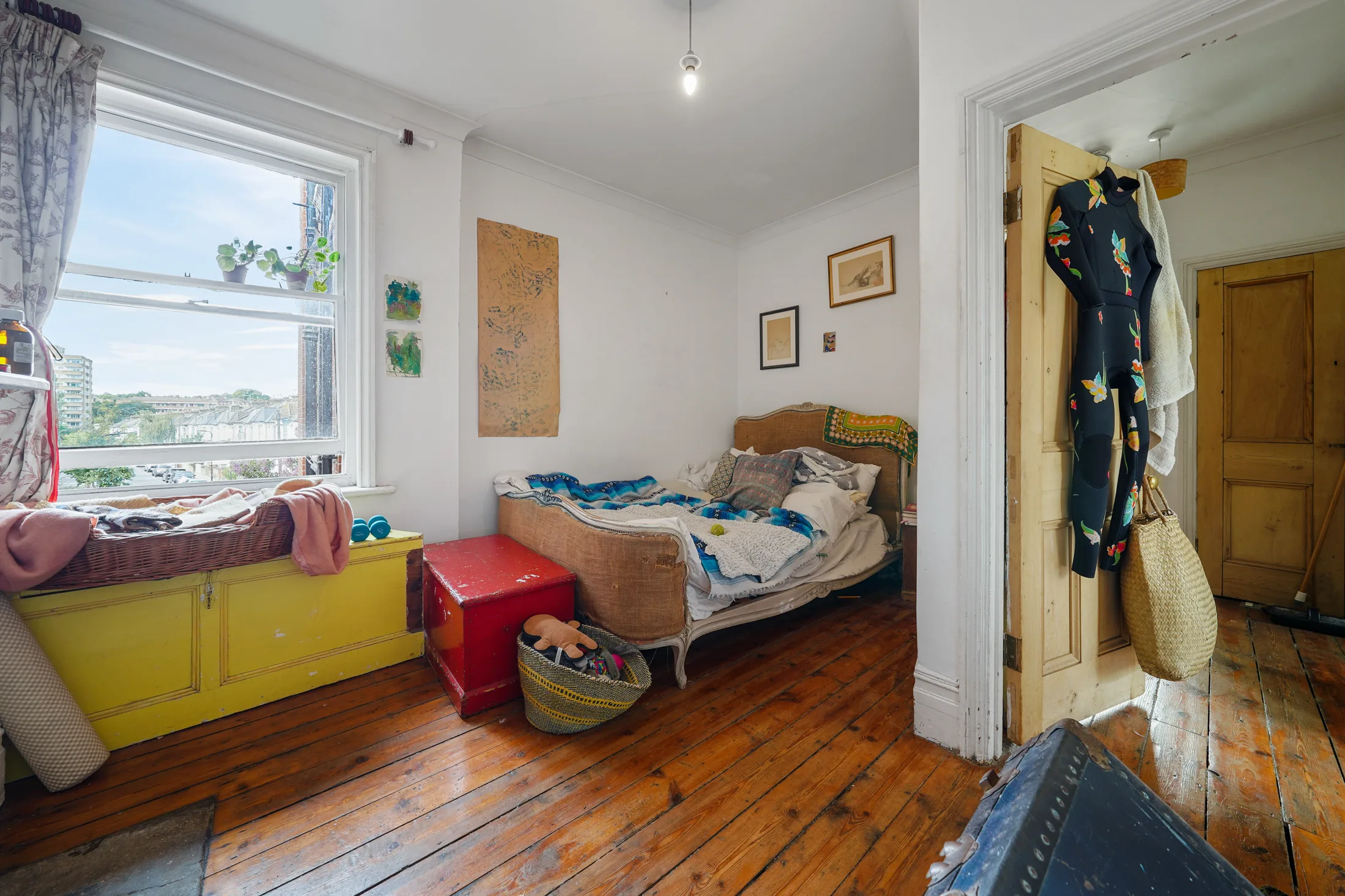 Bedroom with timber flooring, bookshelves and a large window