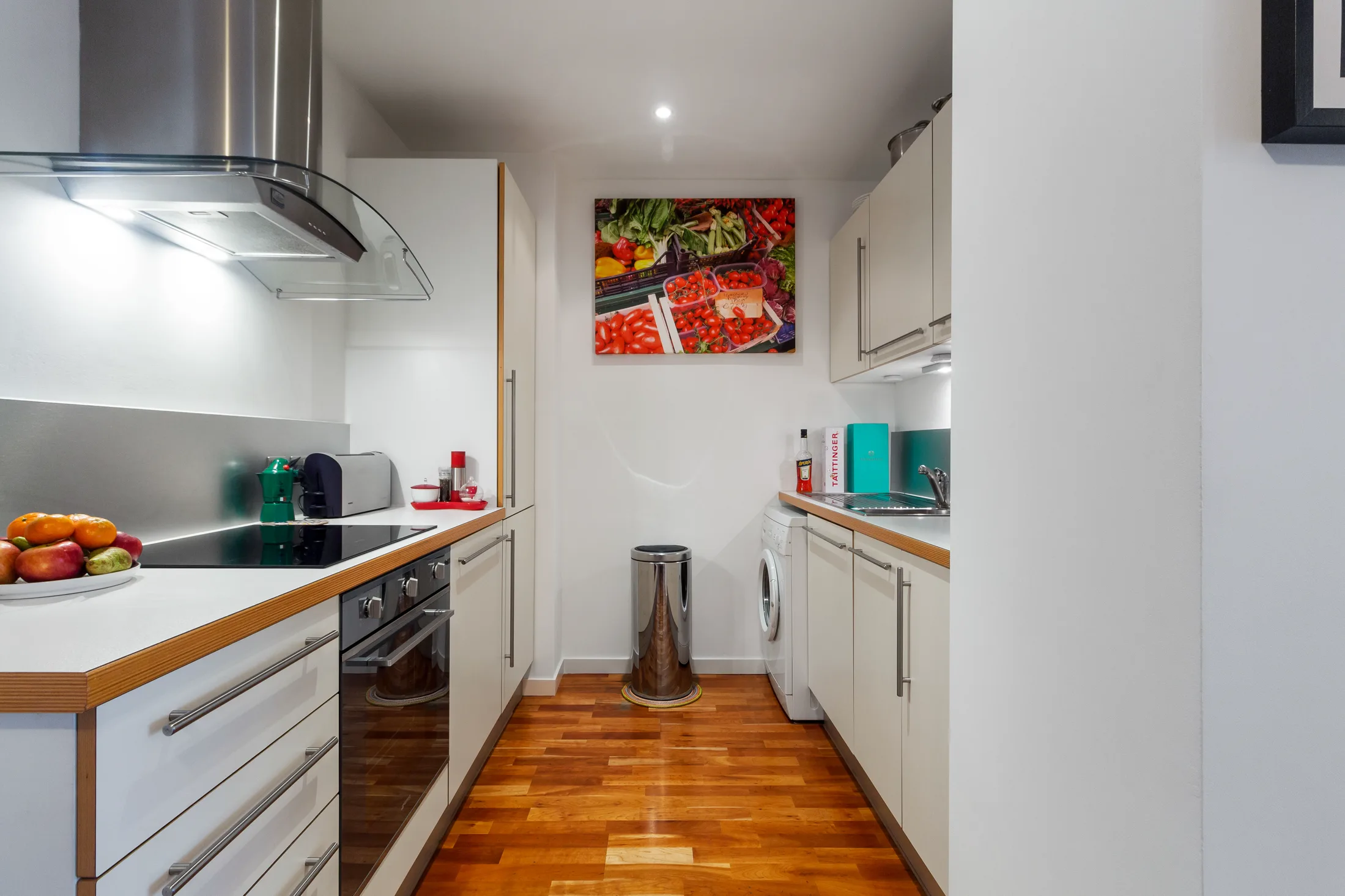 Fitted kitchen with white cabinetry, timber worktops and stainless appliances
