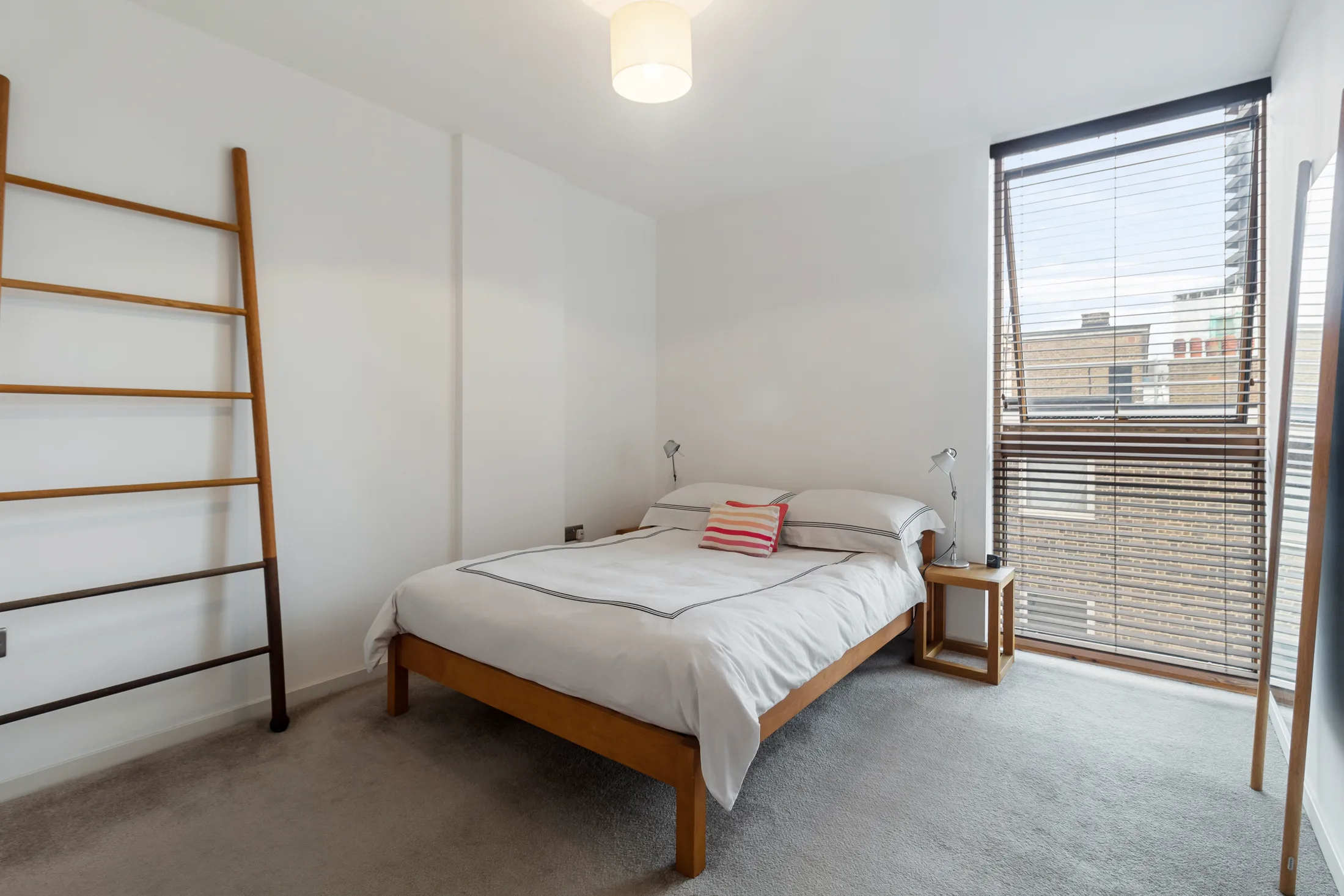 Bedroom with a bed, full-height window and open shelving