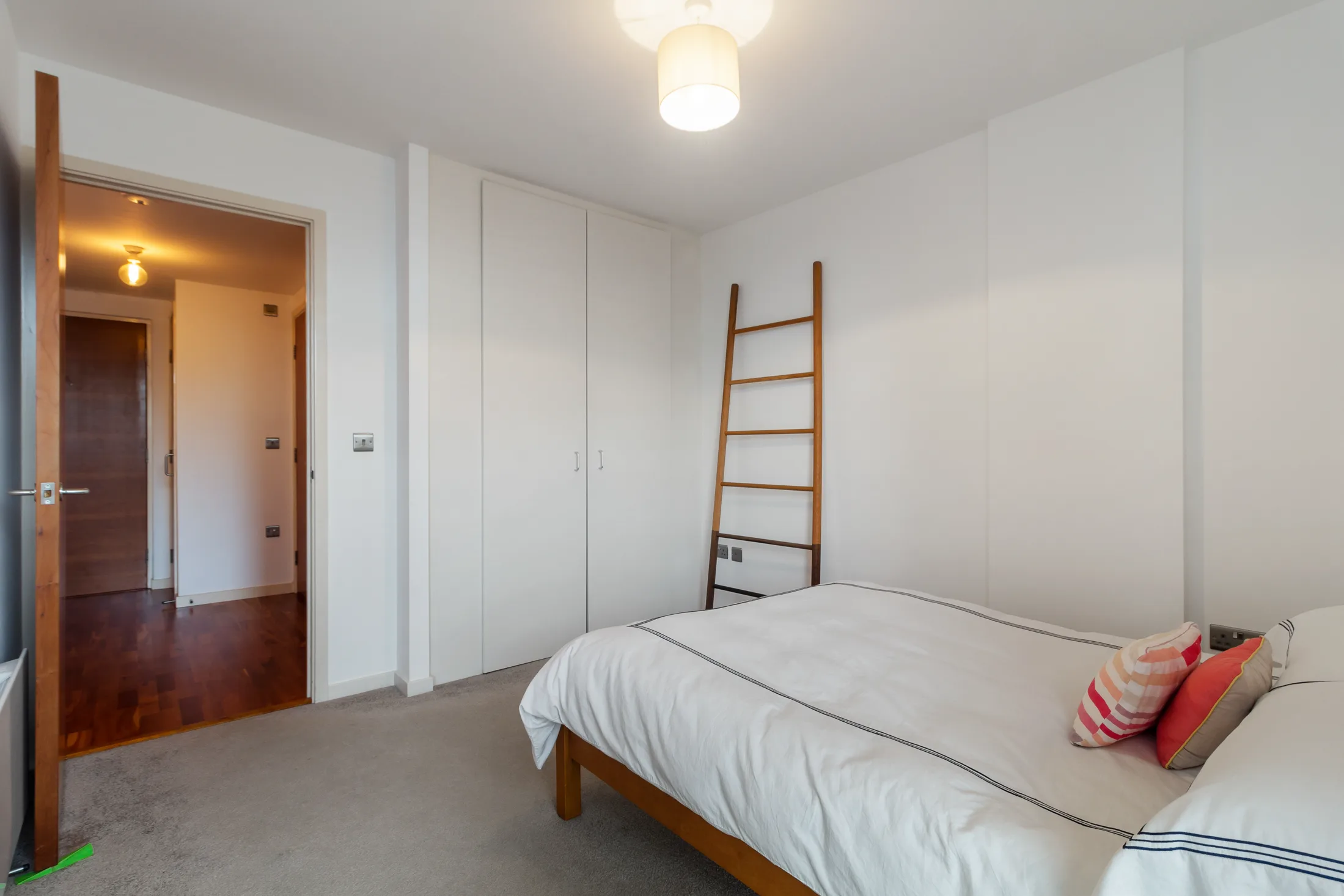 Bedroom with a bed, open shelving and a full-height window