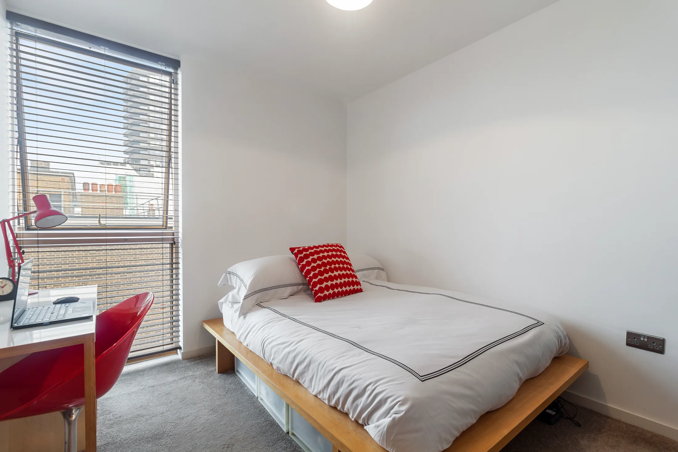 Bedroom with a bed, desk and full-height window