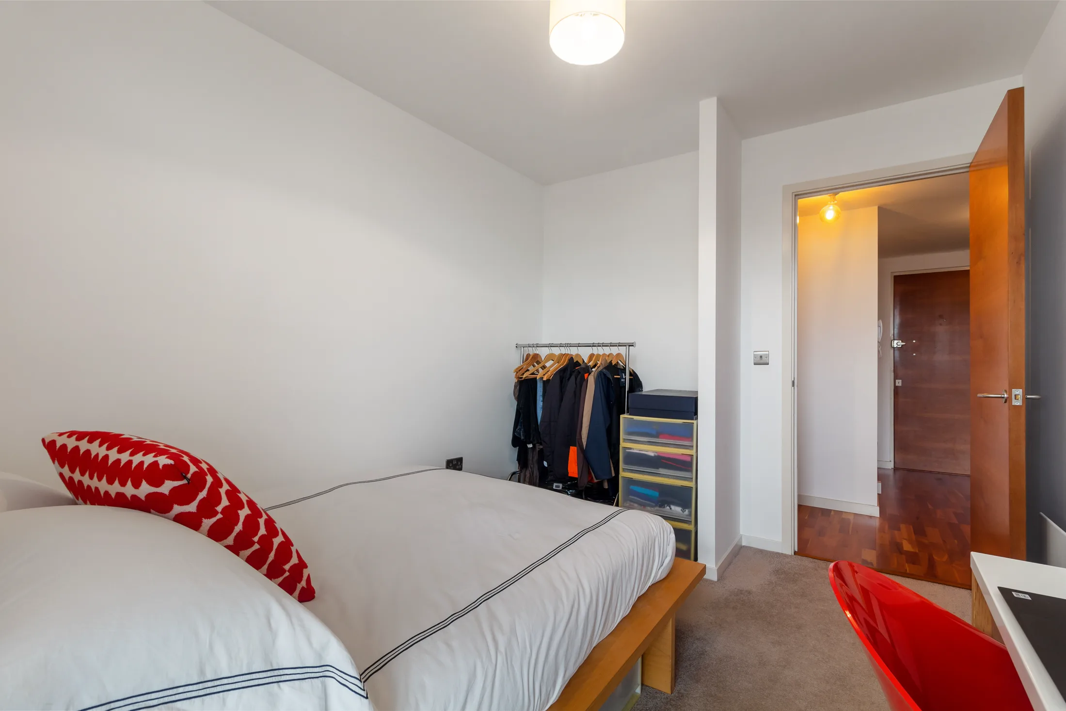 Bedroom with a bed, wardrobe and red accent chair