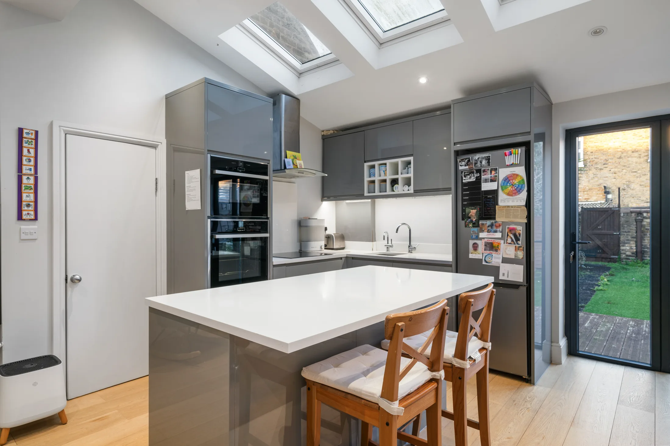 Fitted kitchen with central island, integrated appliances and garden doors