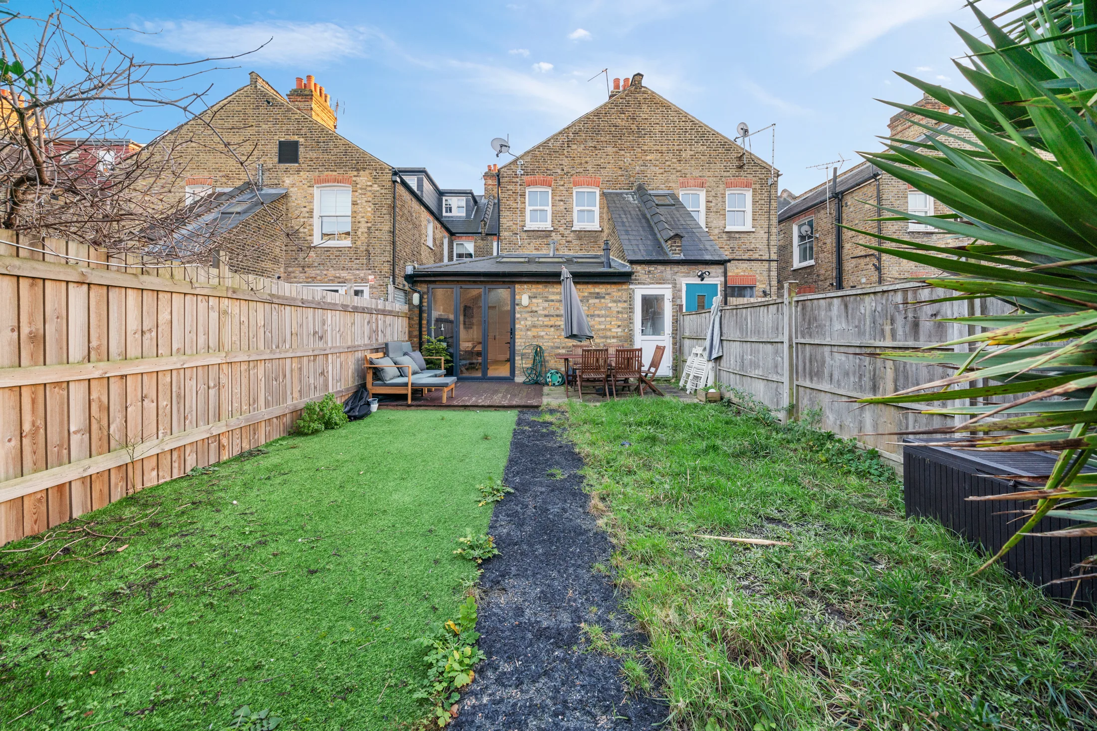 Communal rear garden with lawn, fence and planted borders
