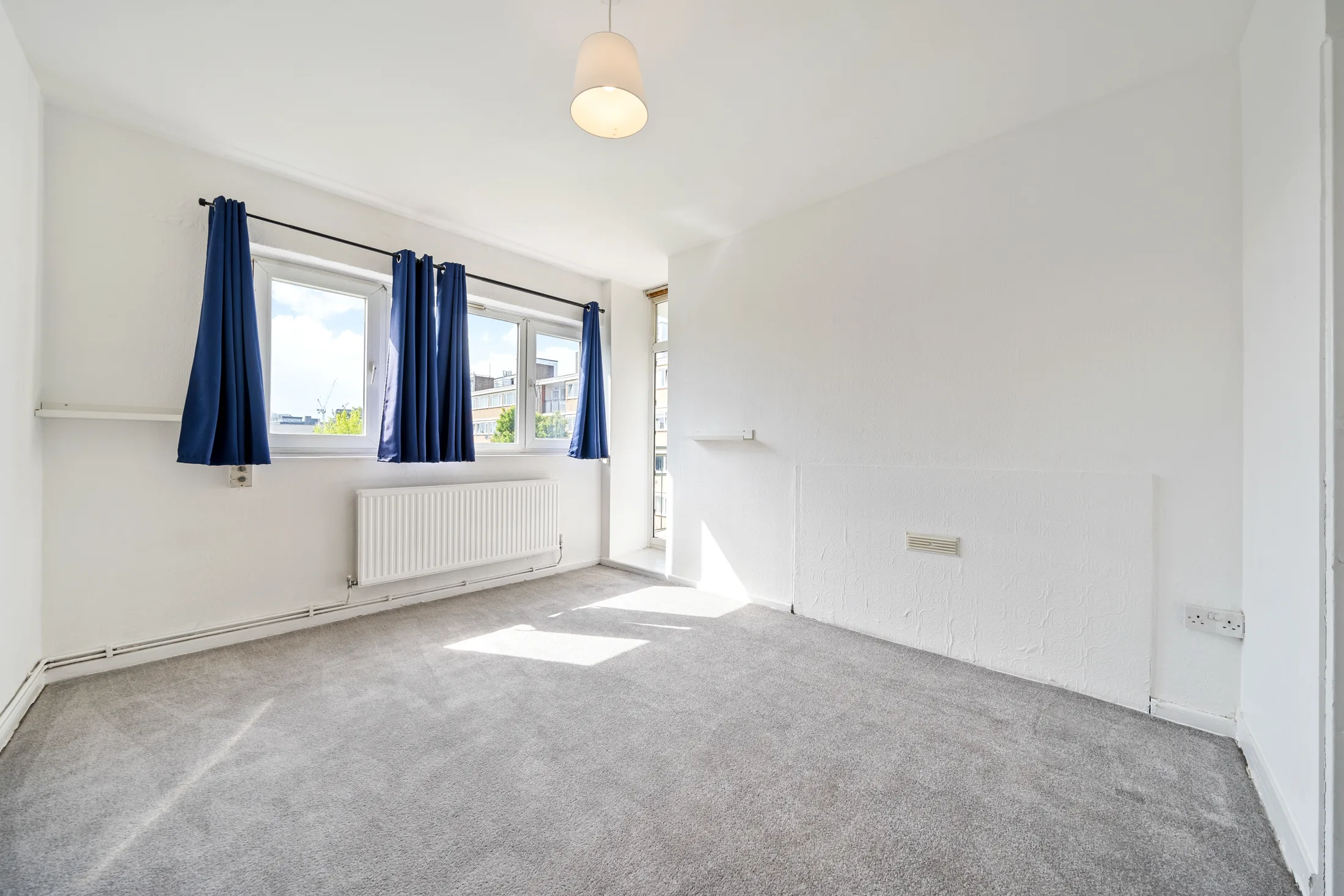 Bedroom with carpet, a large window and curtains