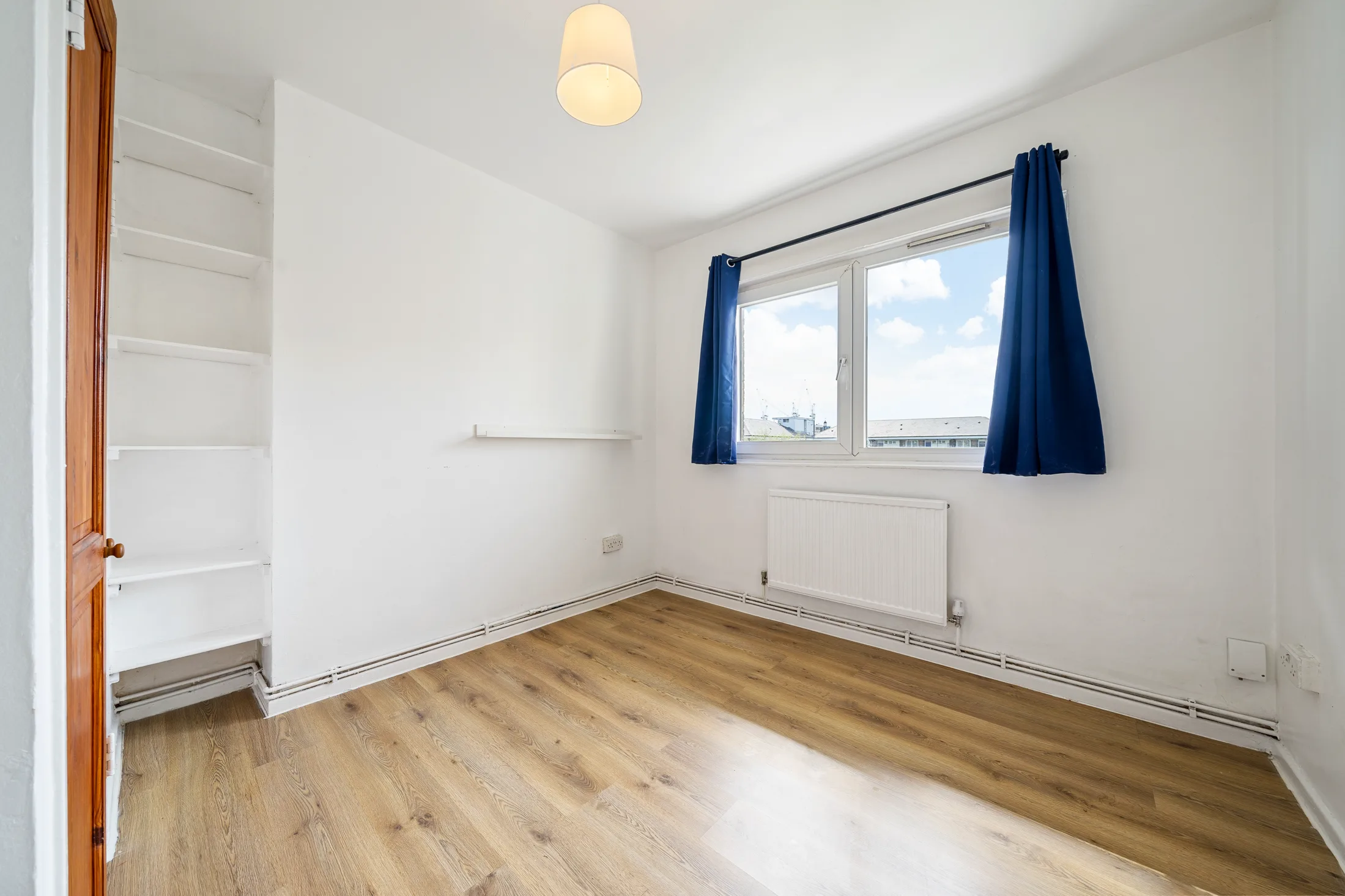 Bedroom with timber flooring and a large window