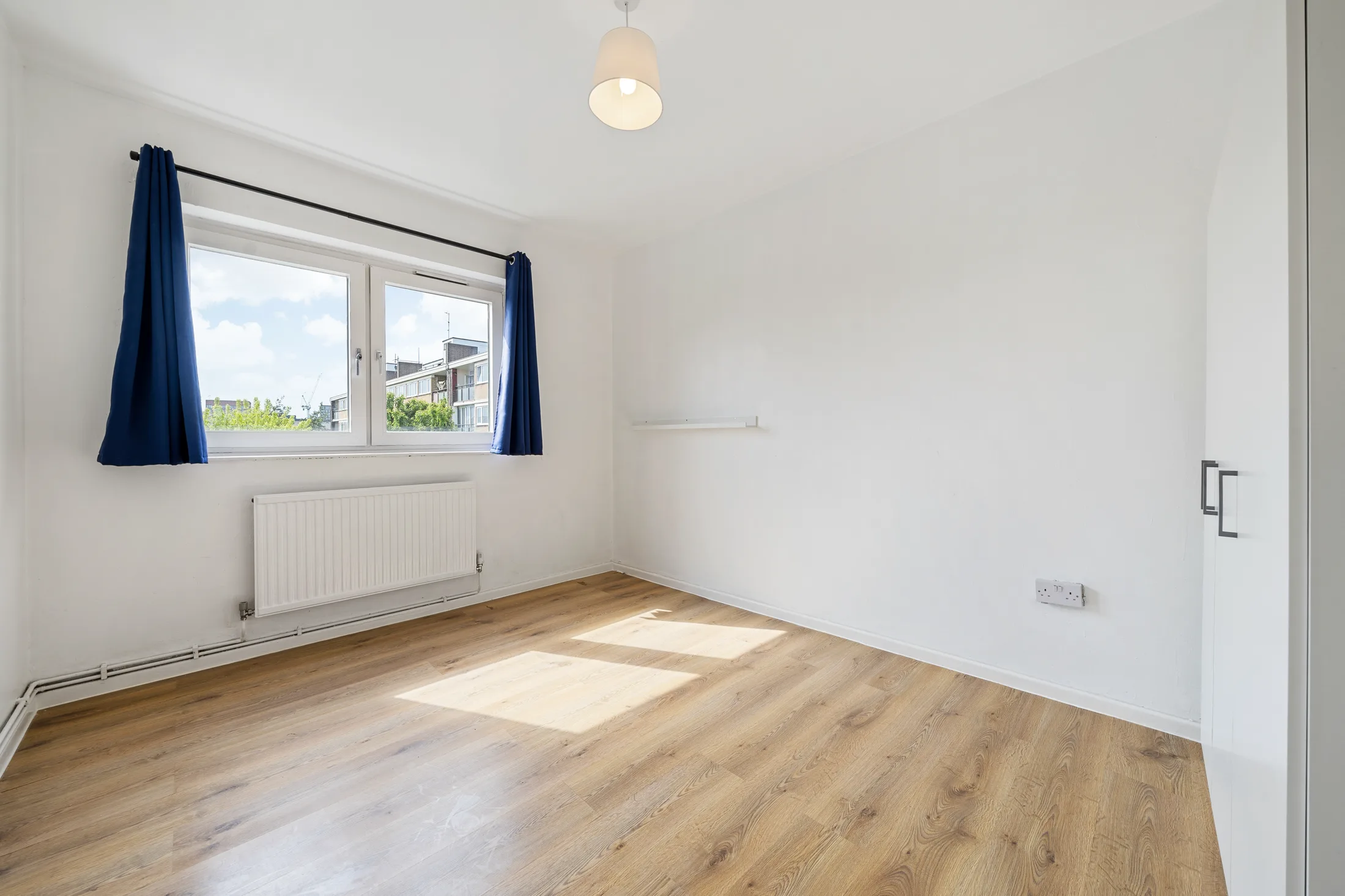 Bedroom with timber flooring and curtains