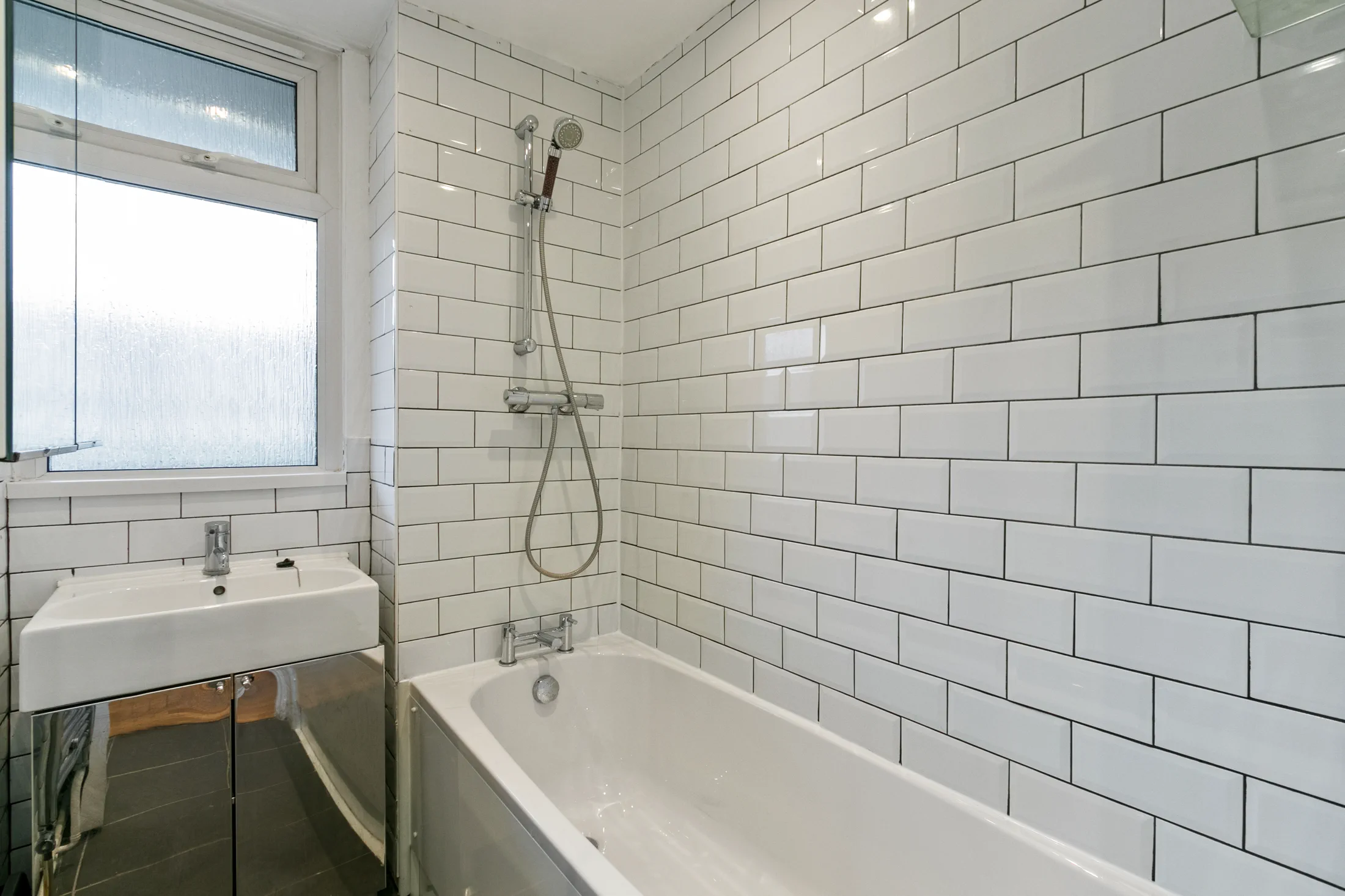 Bathroom with a bath and tiled walls