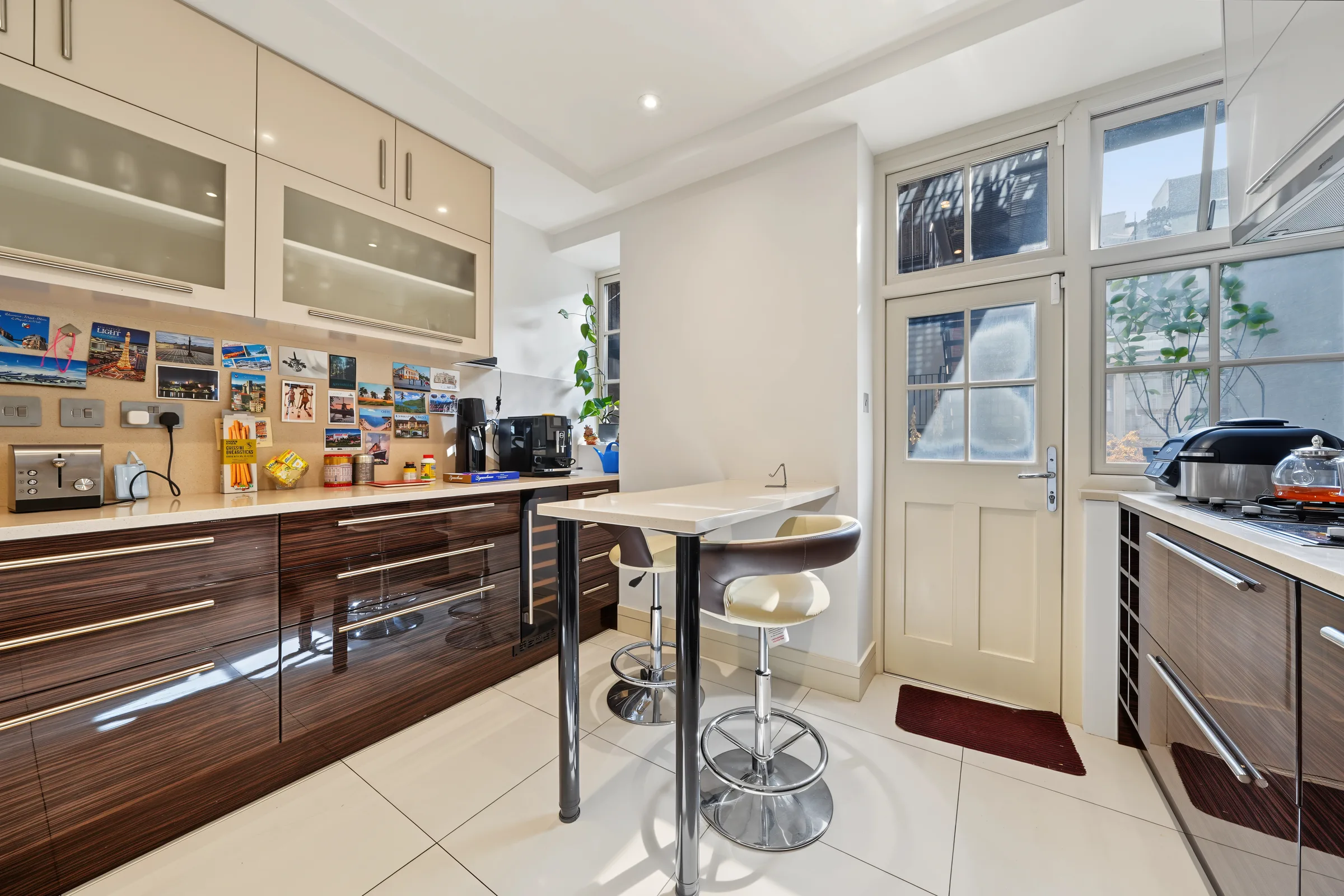 Kitchen and dining room with tiled floor and fitted cabinetry