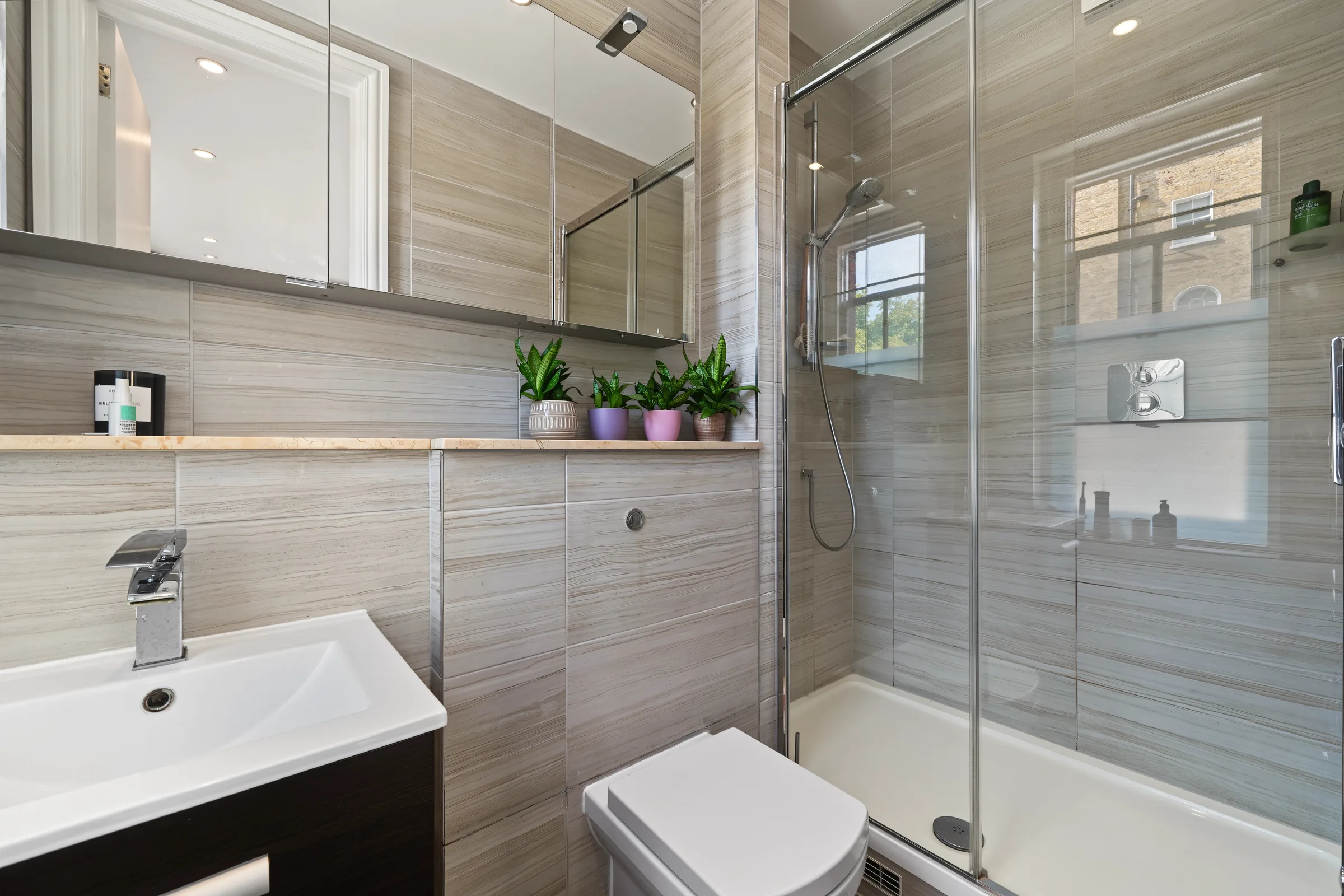 Tiled bathroom with a glass-screened shower