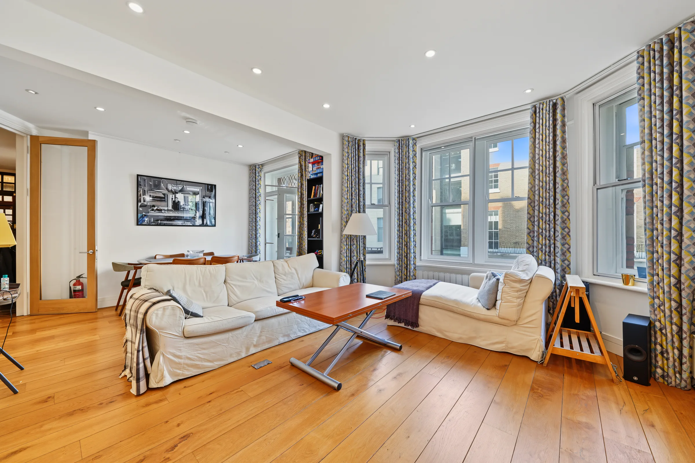 21-foot reception room with a sofa, dining table and tall windows