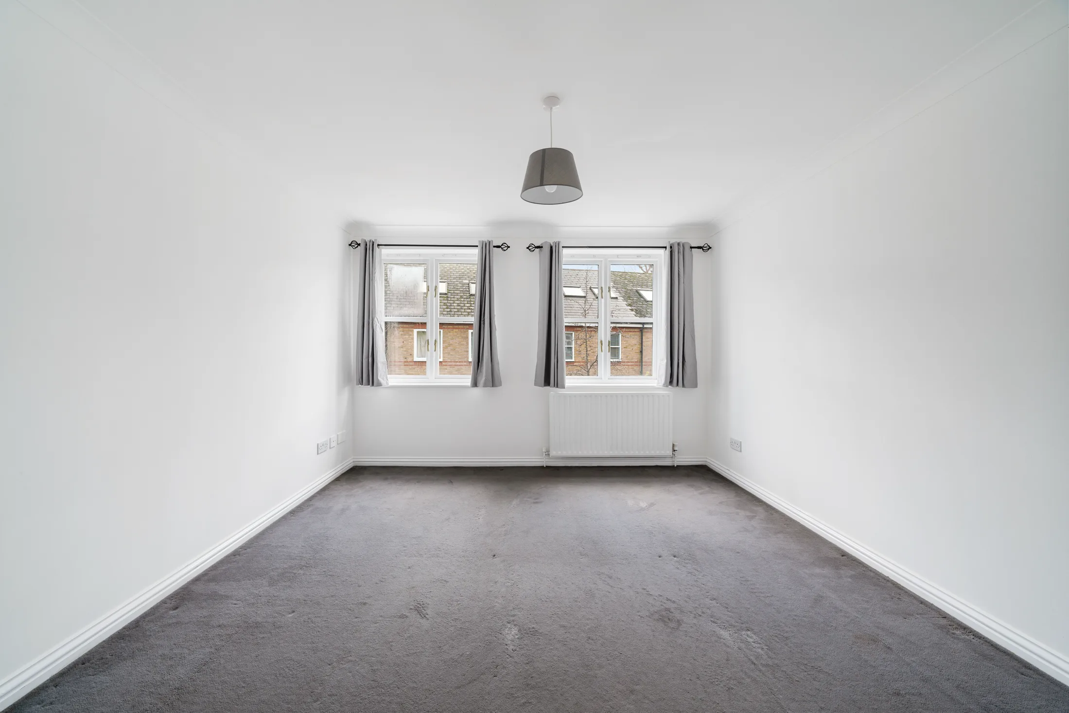 Bedroom with dark carpet, curtains and radiator