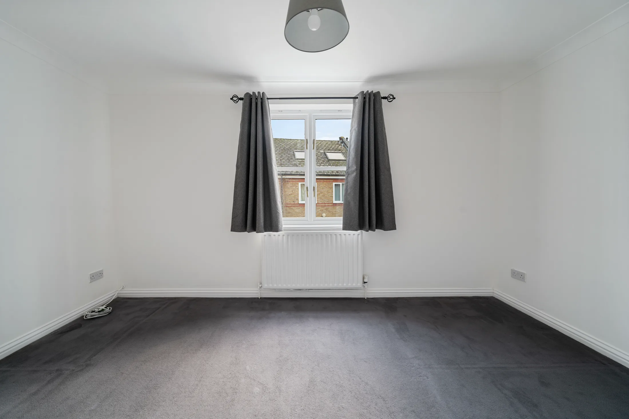 Bedroom with dark carpet, curtains and window