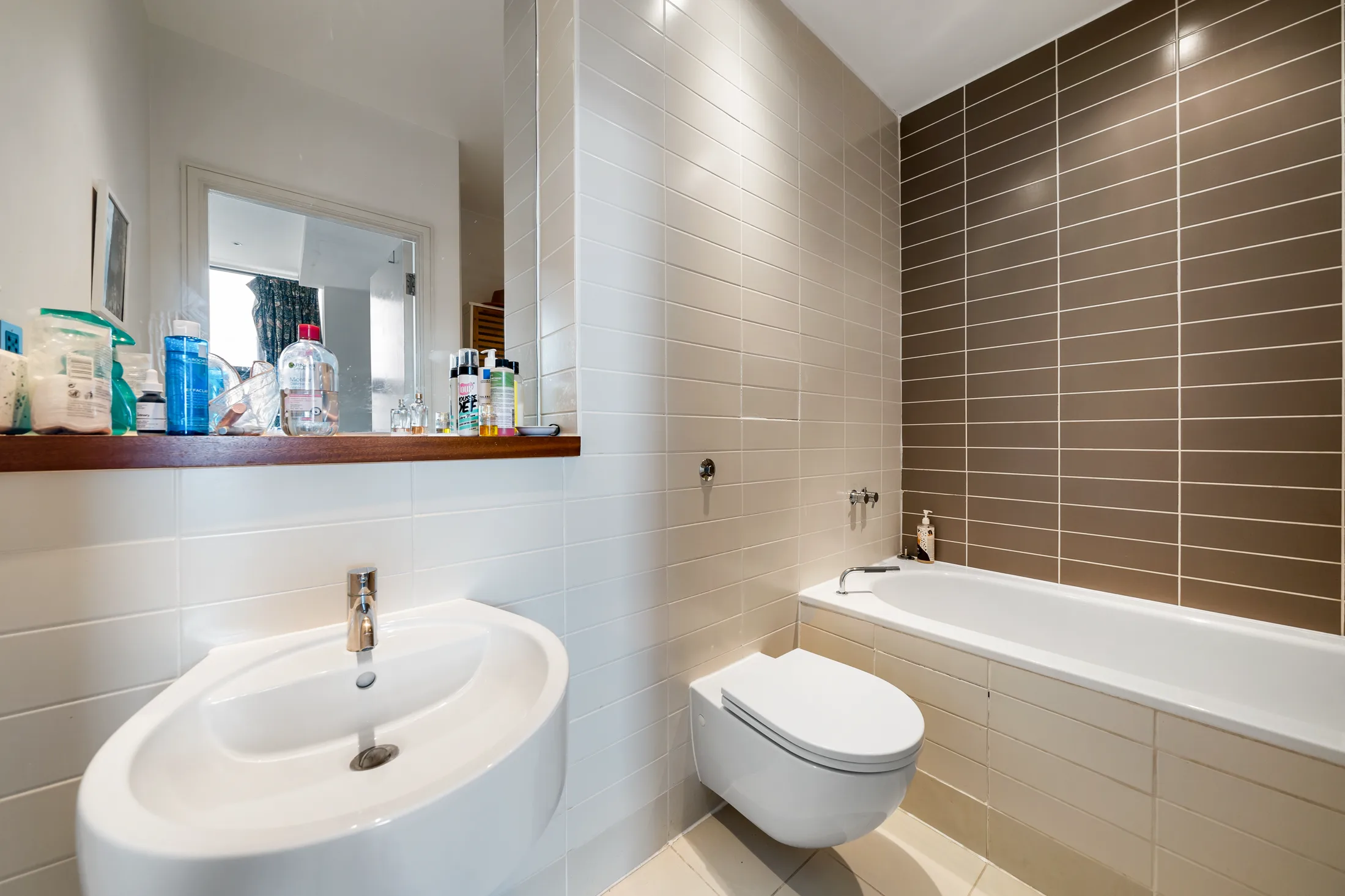 Bathroom with a bath, wall-mounted basin and tiled walls