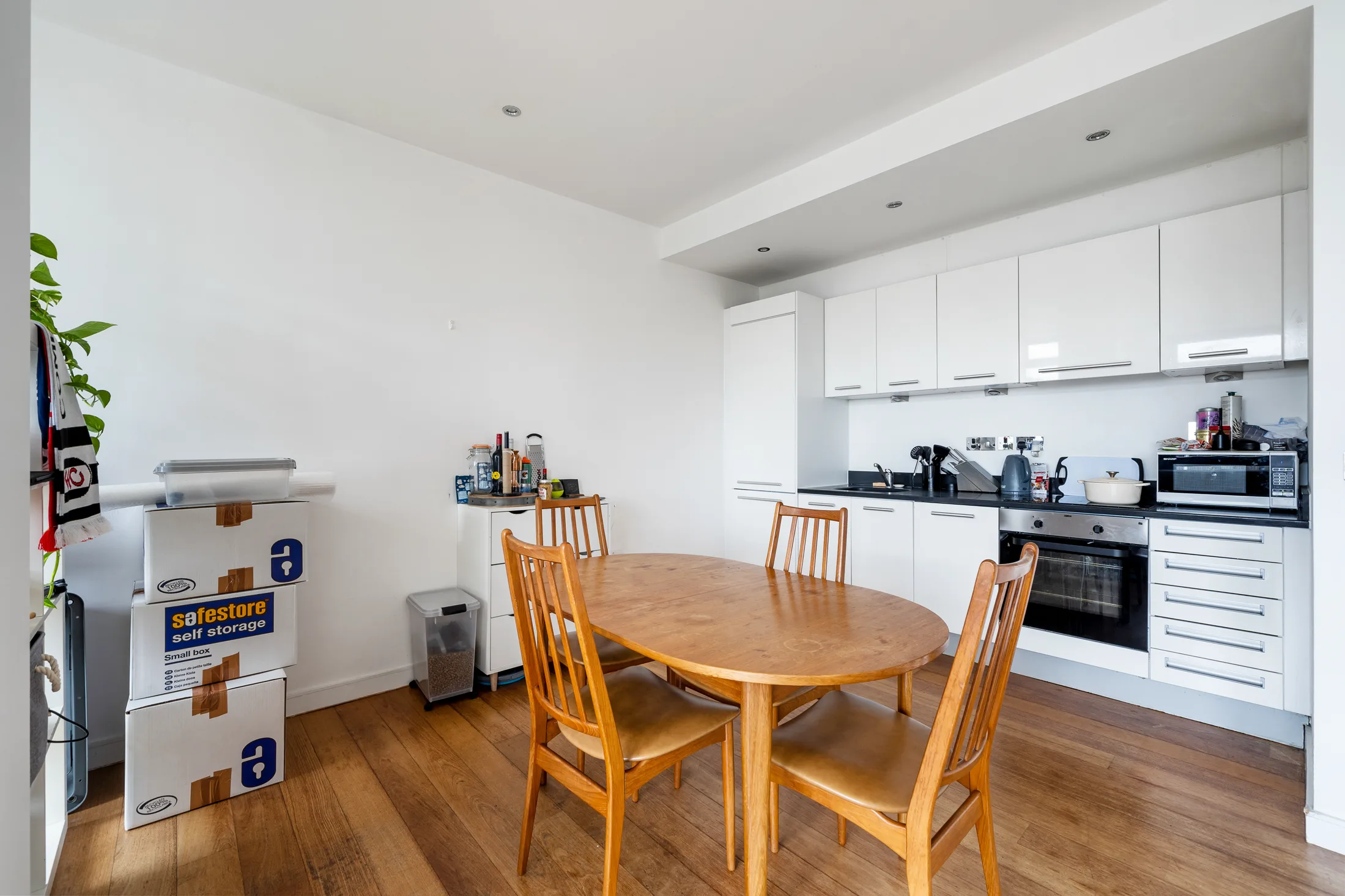 Open-plan kitchen and dining area with white fitted cabinetry