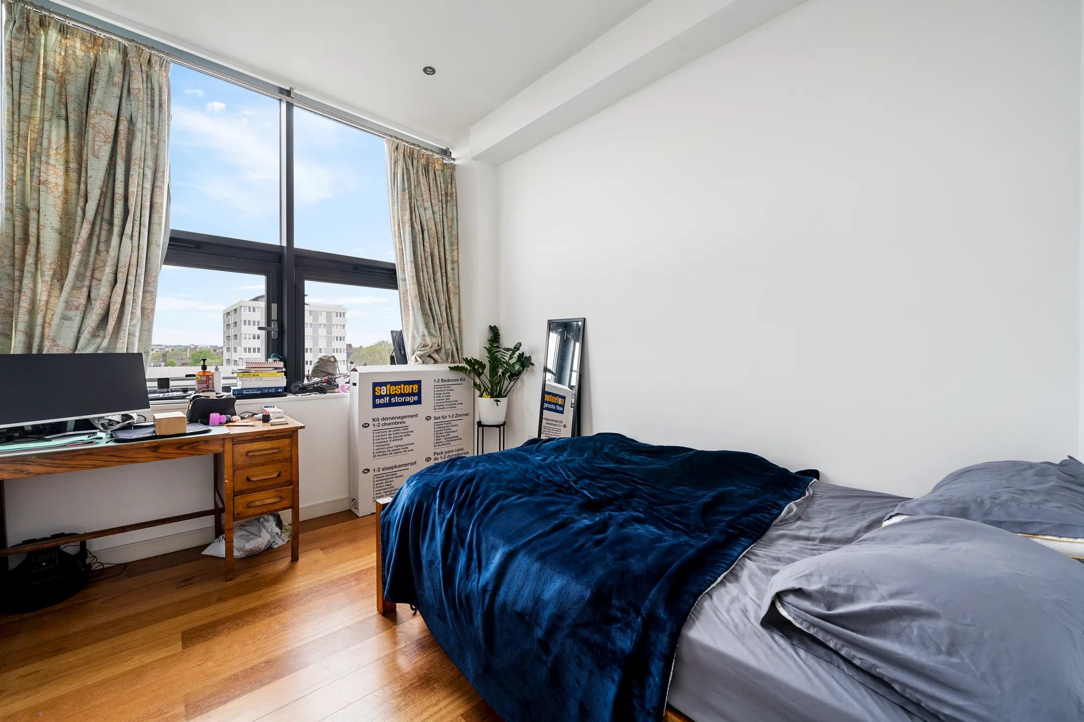 Bedroom with a large window and fitted storage