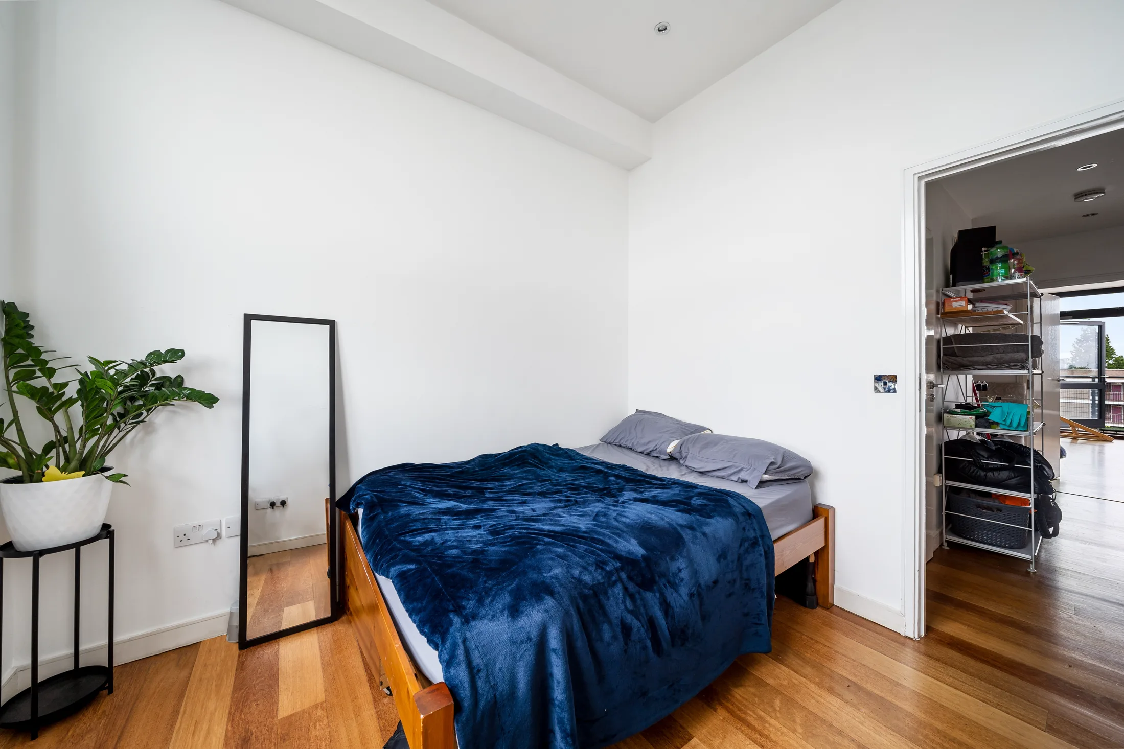 Second bedroom with timber flooring and a large window