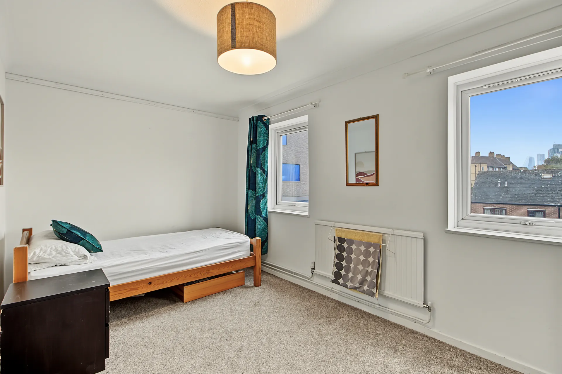 Bright bedroom with a single bed and a view over the rooftops