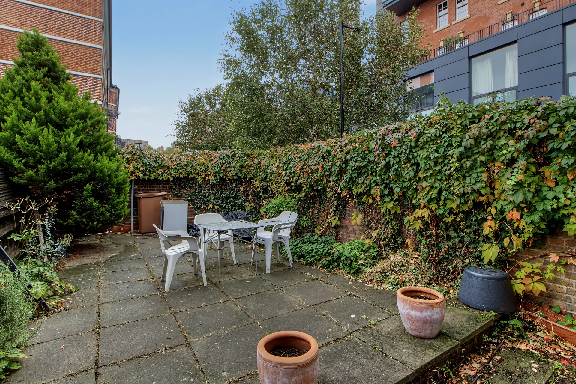 Private paved garden with outdoor seating and ivy-covered walls