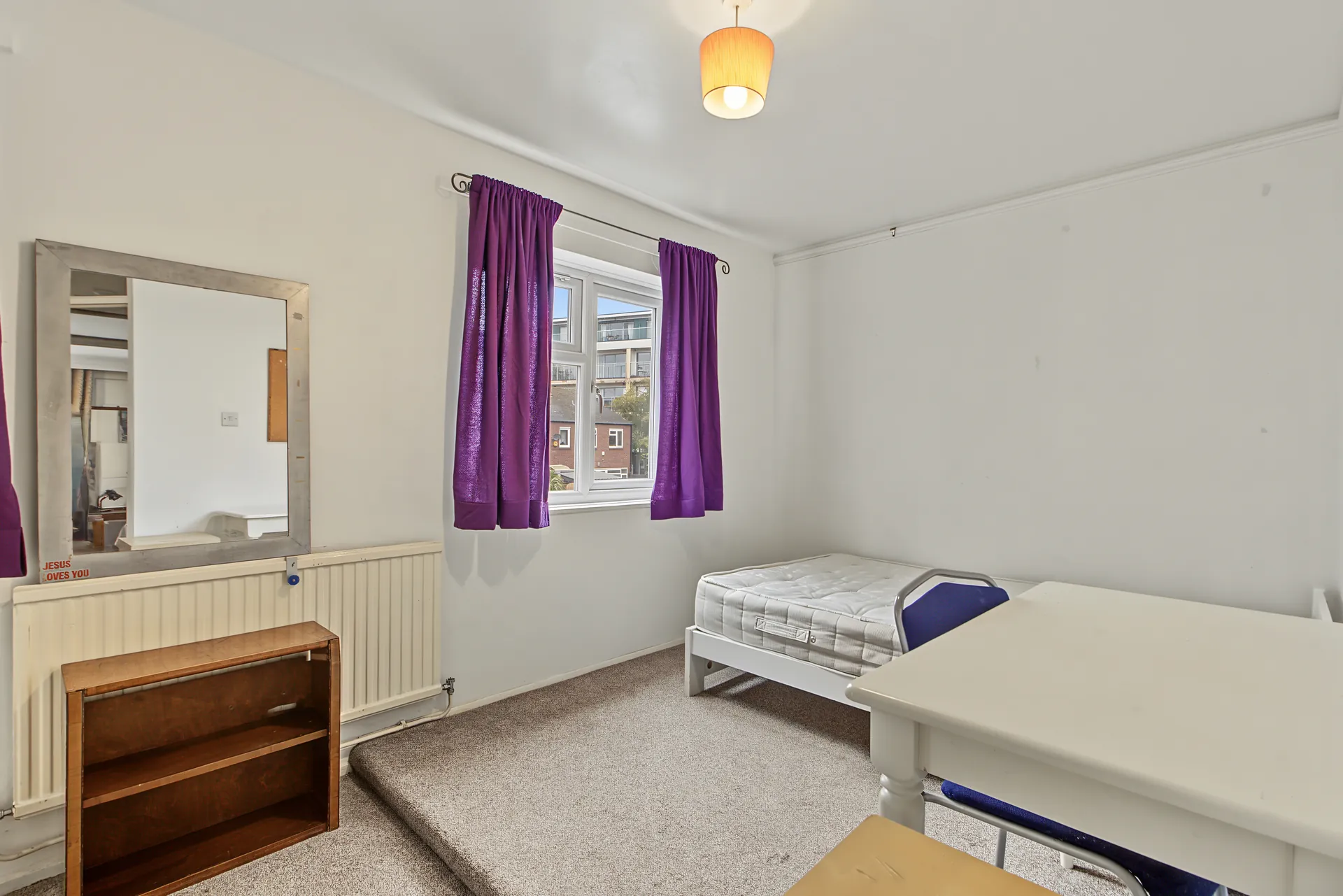 Bedroom with a single bed, desk and window