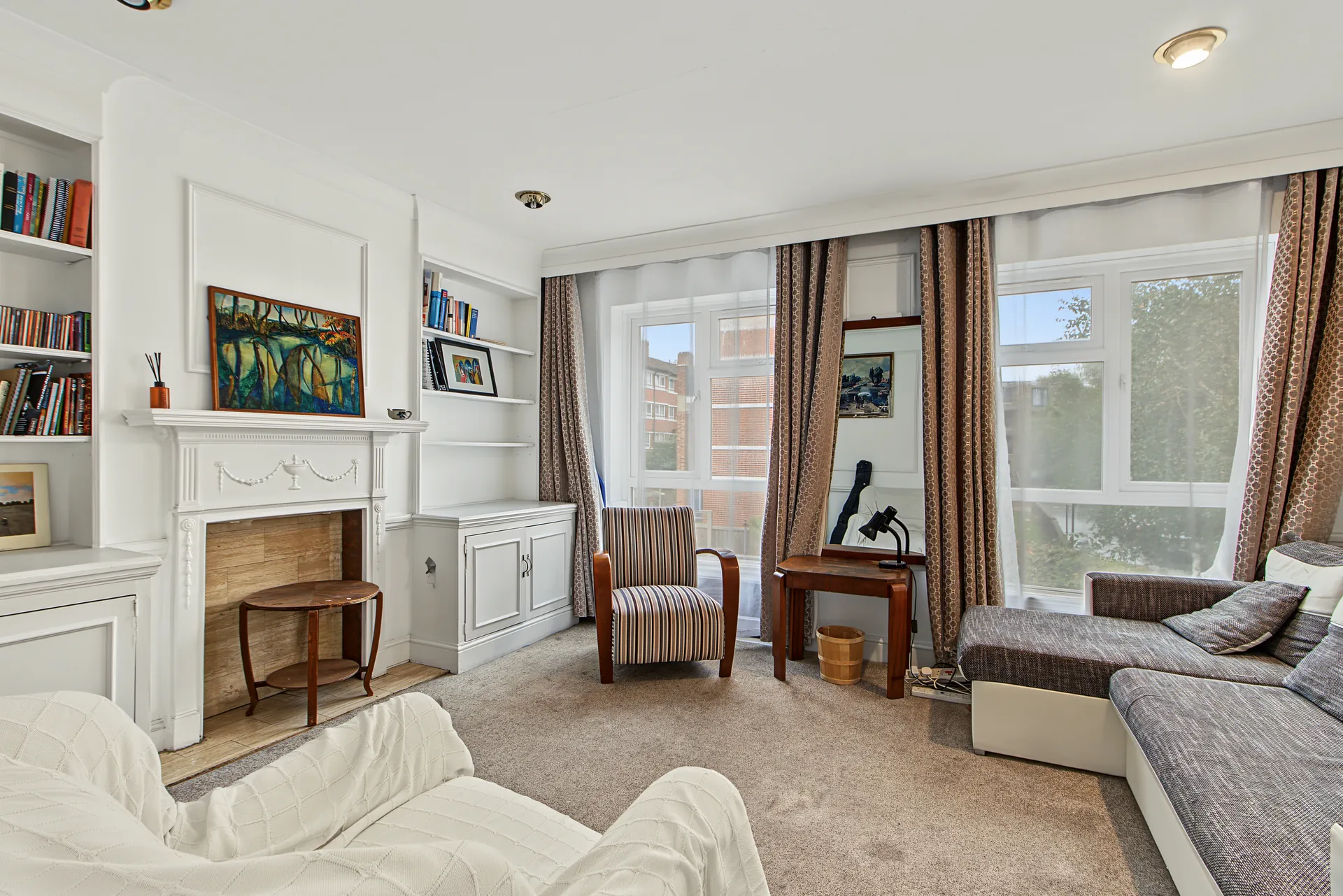 First-floor reception room with built-in bookshelves and a period fireplace