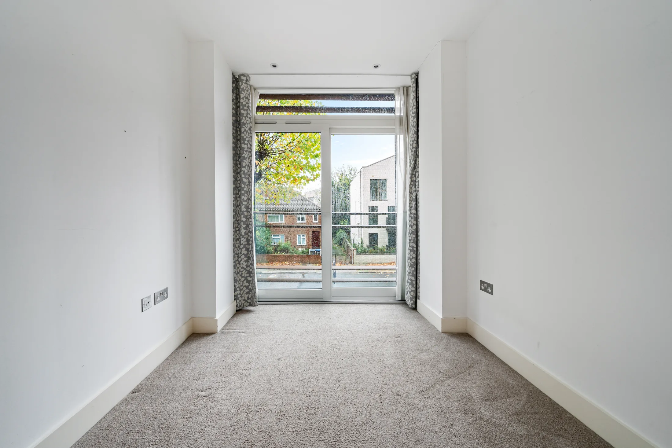 Bedroom with carpet and glazed doors to a balcony