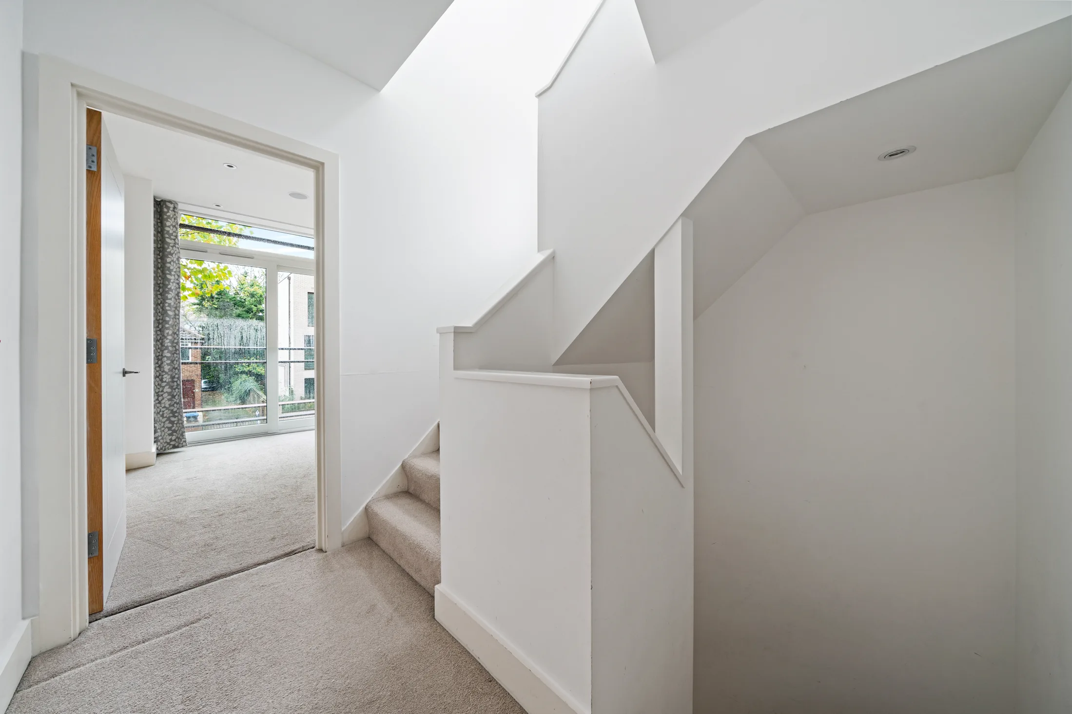 Hallway and staircase with white walls and fitted storage