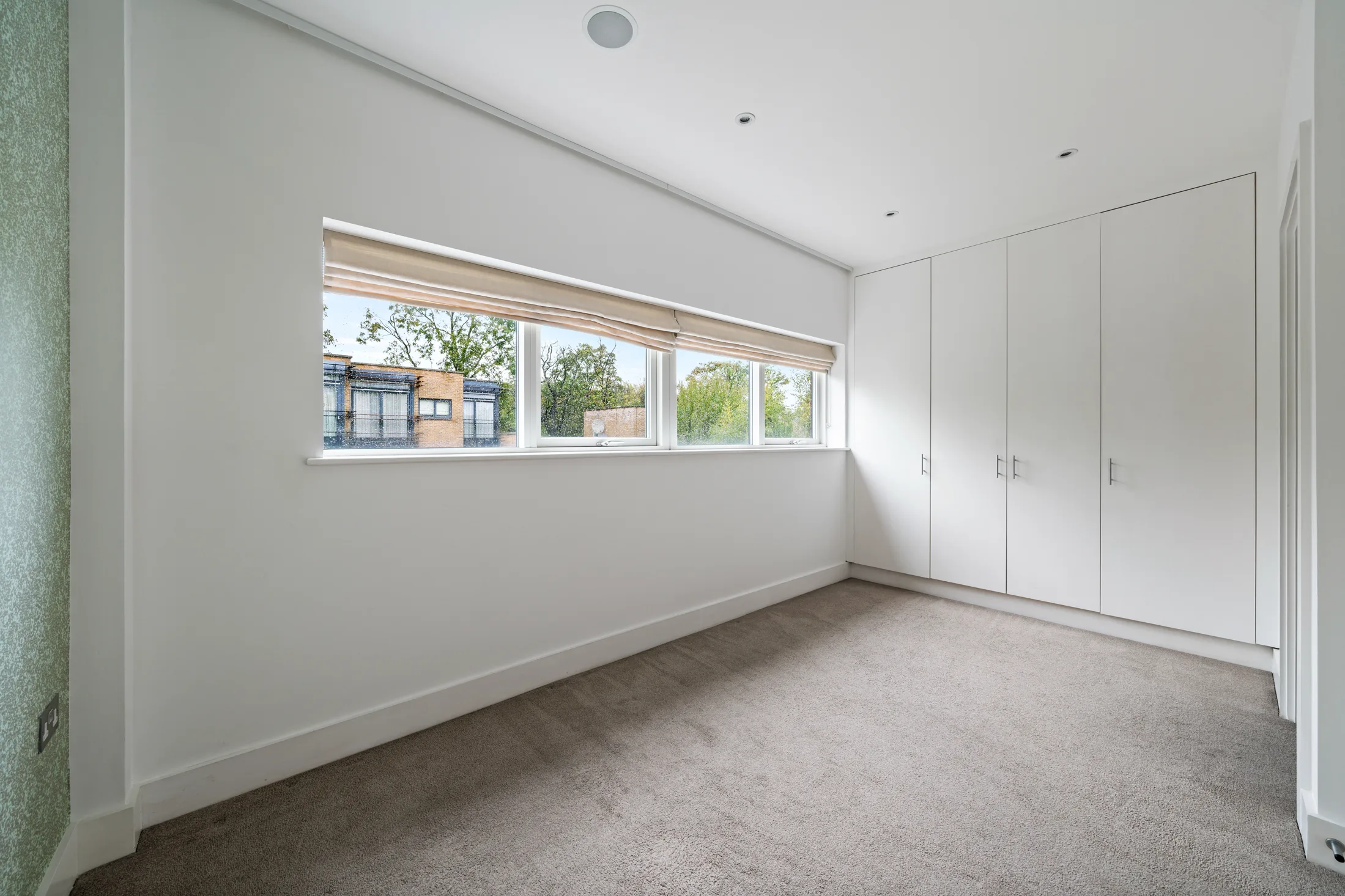 Bedroom with fitted wardrobe and long window