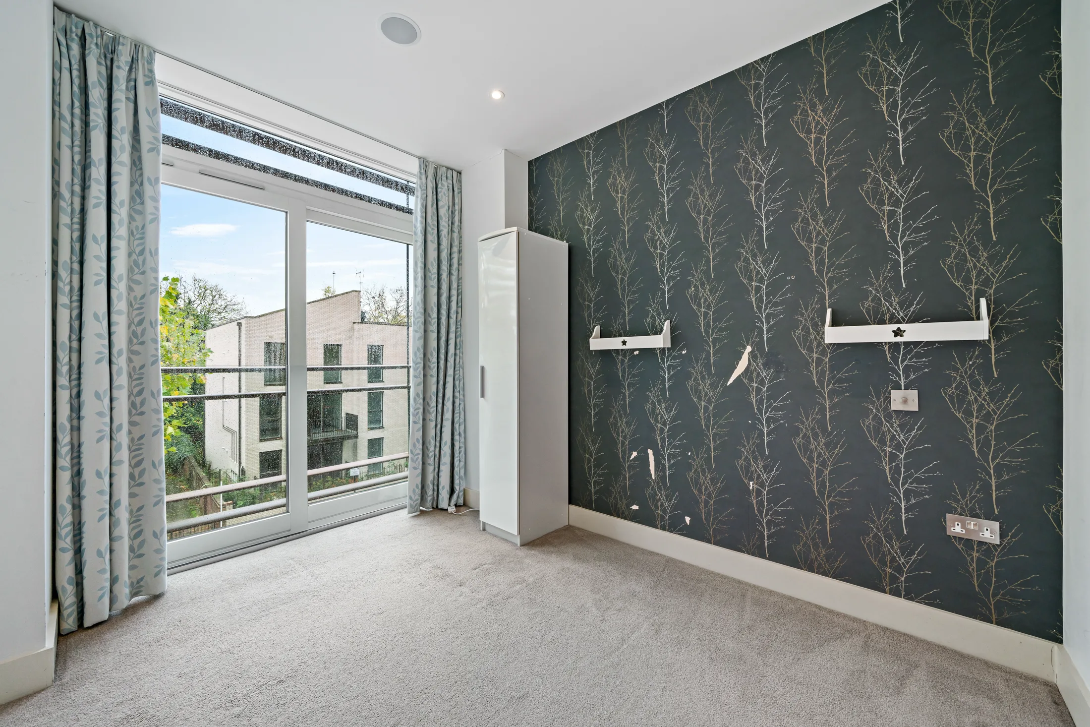 Bedroom with dark feature wall and balcony doors