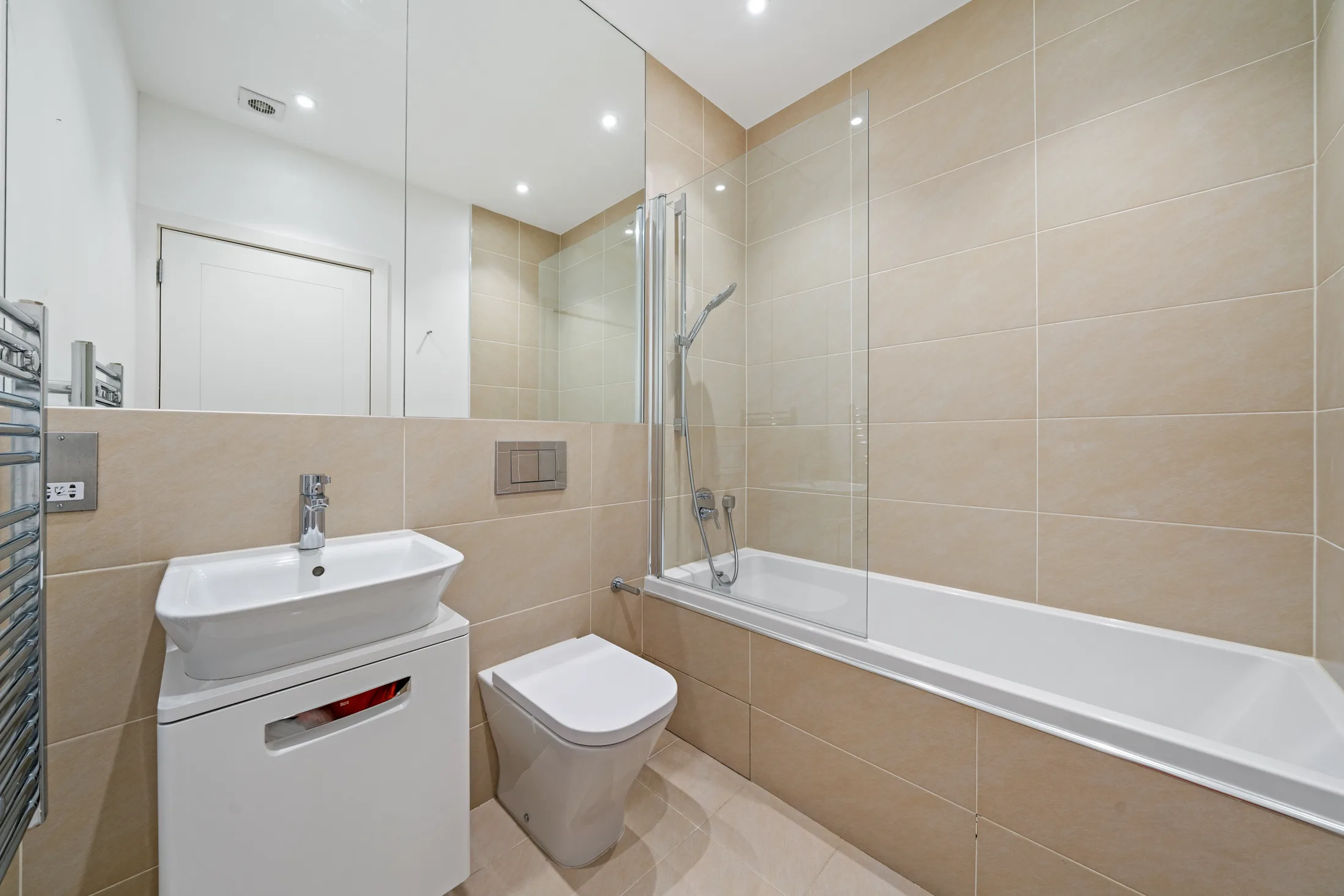 Bathroom with bath, wall-mounted basin and tiled walls