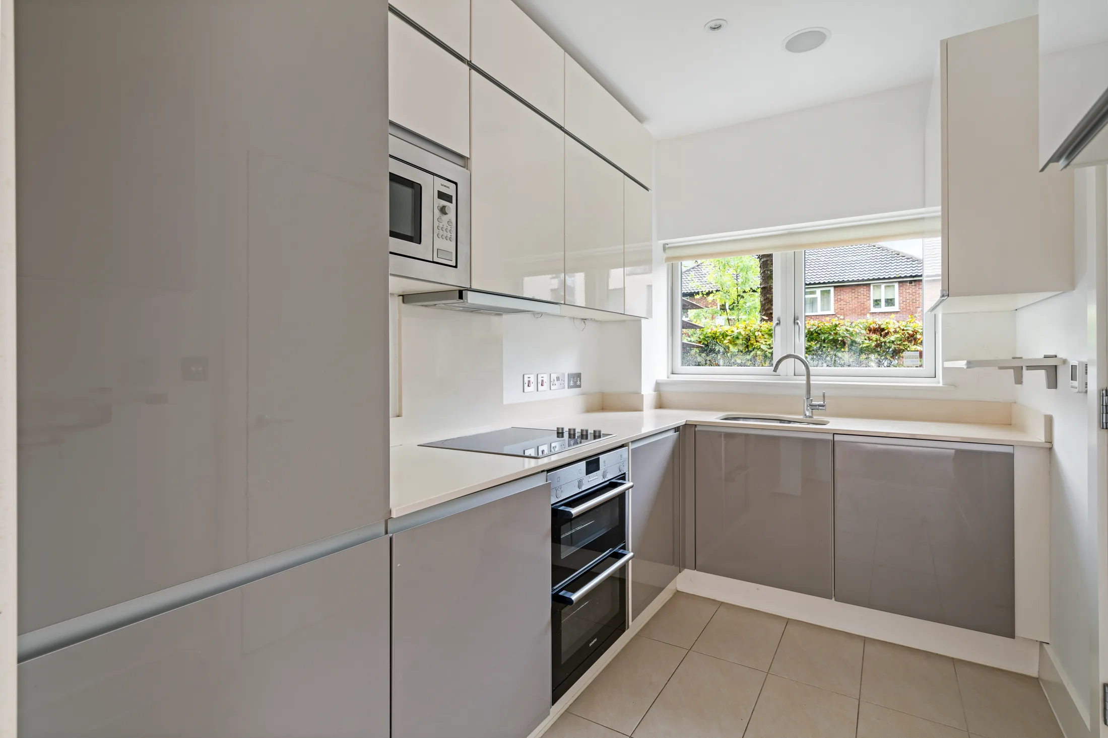 Fitted kitchen with pale cabinetry and integrated appliances