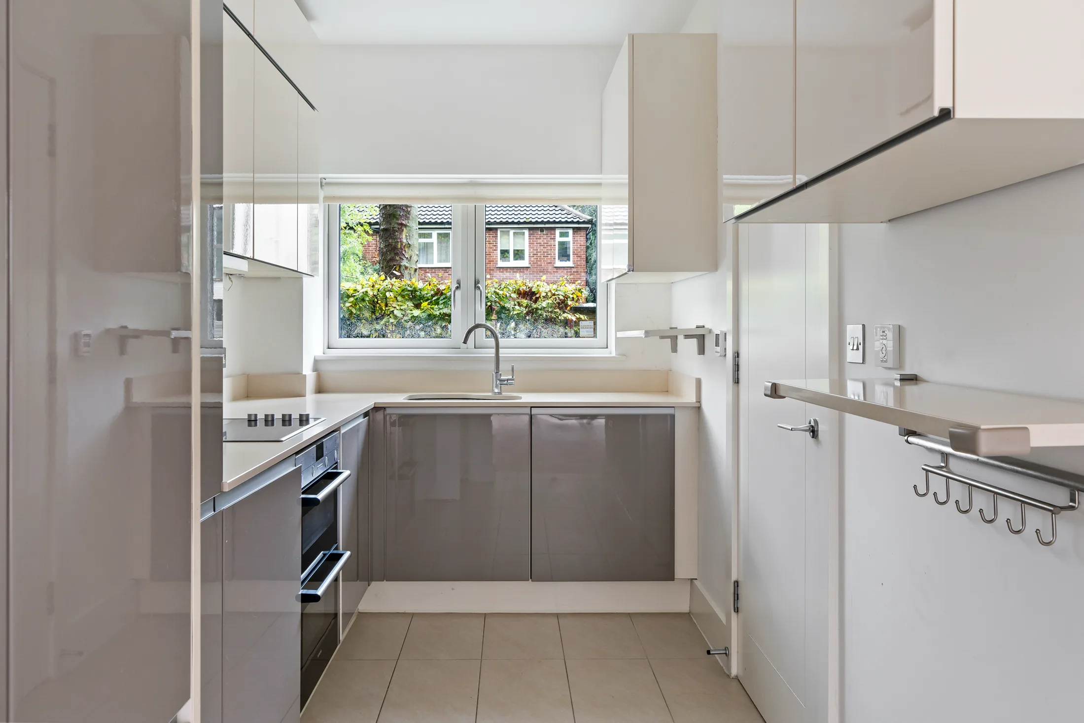 Kitchen with fitted cabinetry, worktops and garden-facing window
