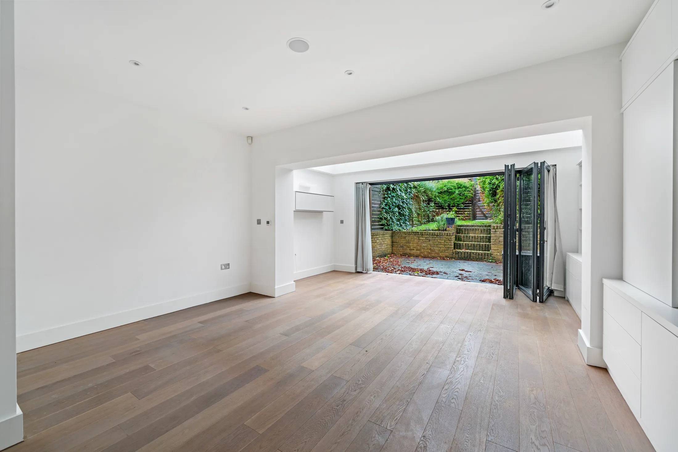 Reception room with timber flooring and garden-facing doors