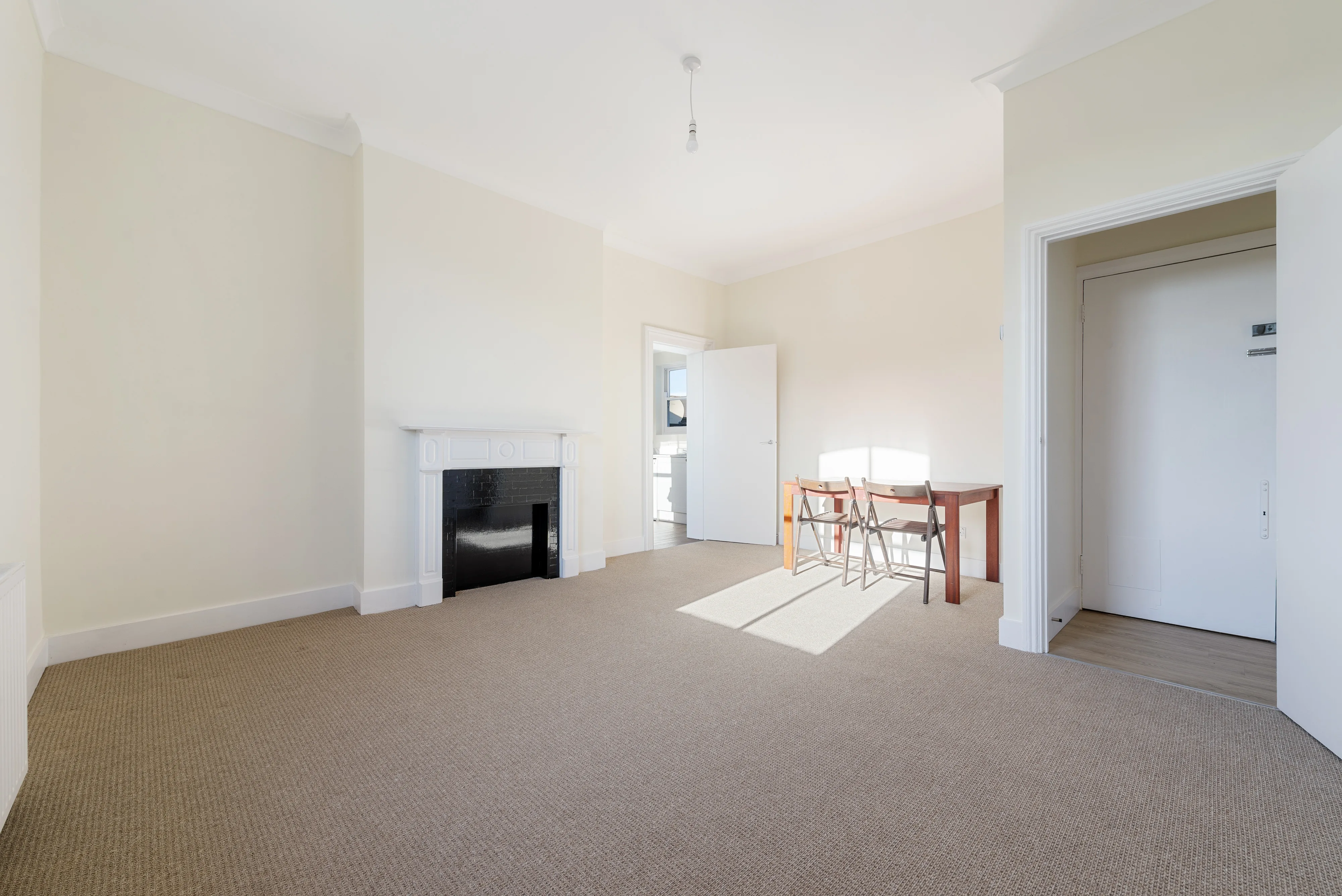 Reception room with a dining table, large window and fireplace