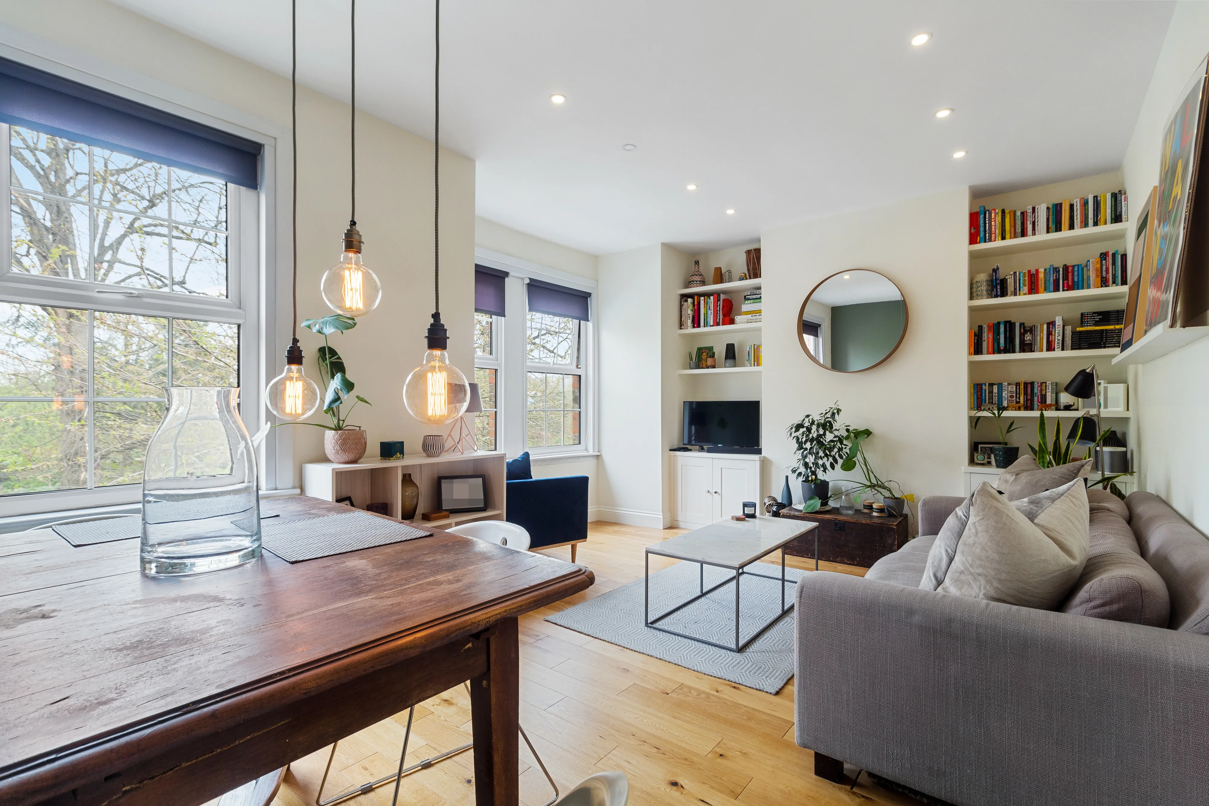 Reception and dining room with large windows, pendant lights and built-in shelving