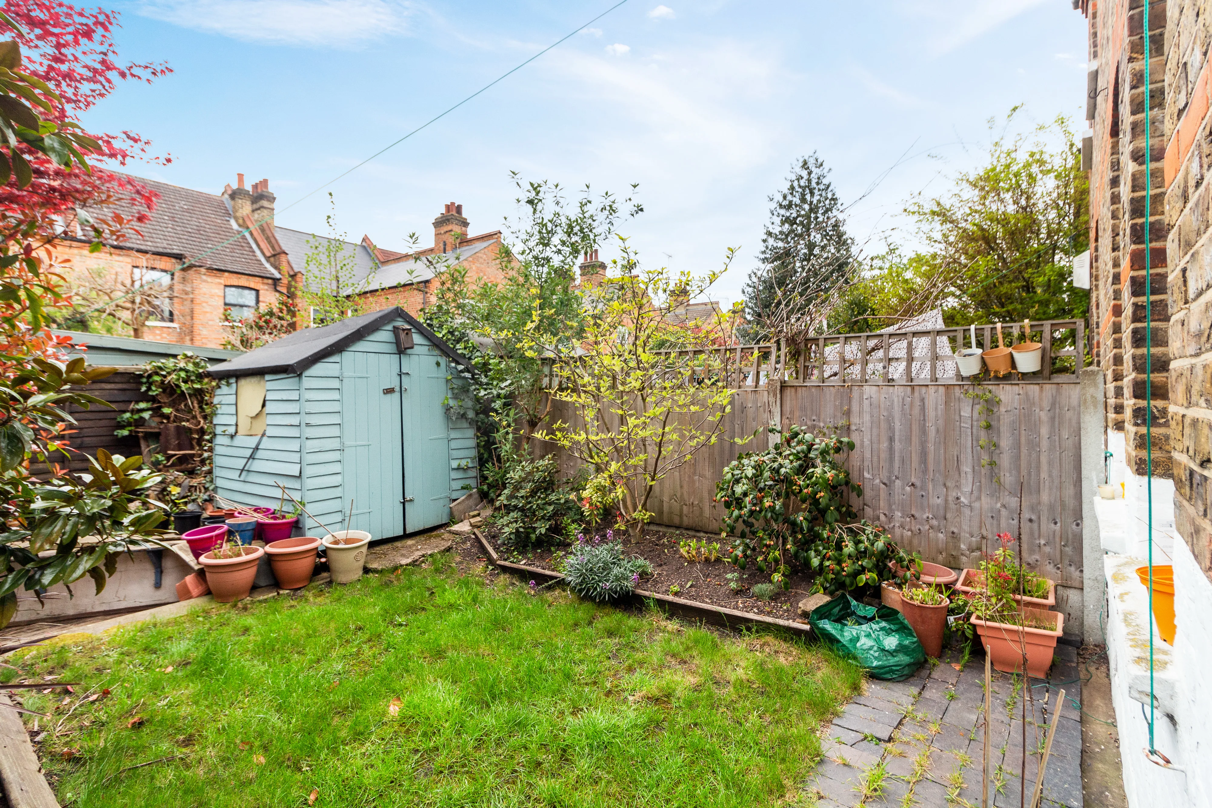 Shared garden with lawn, planting beds and a garden shed
