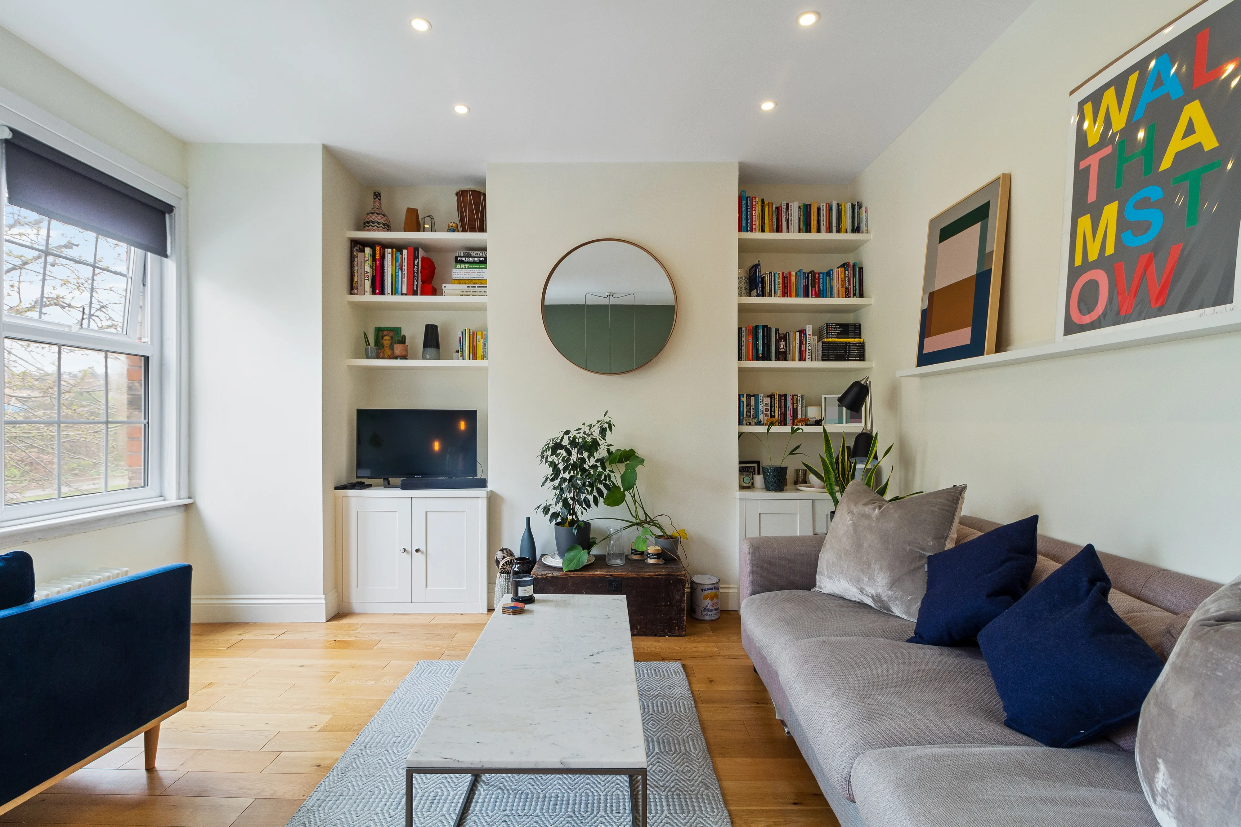 Reception room with fitted shelving, television and large window