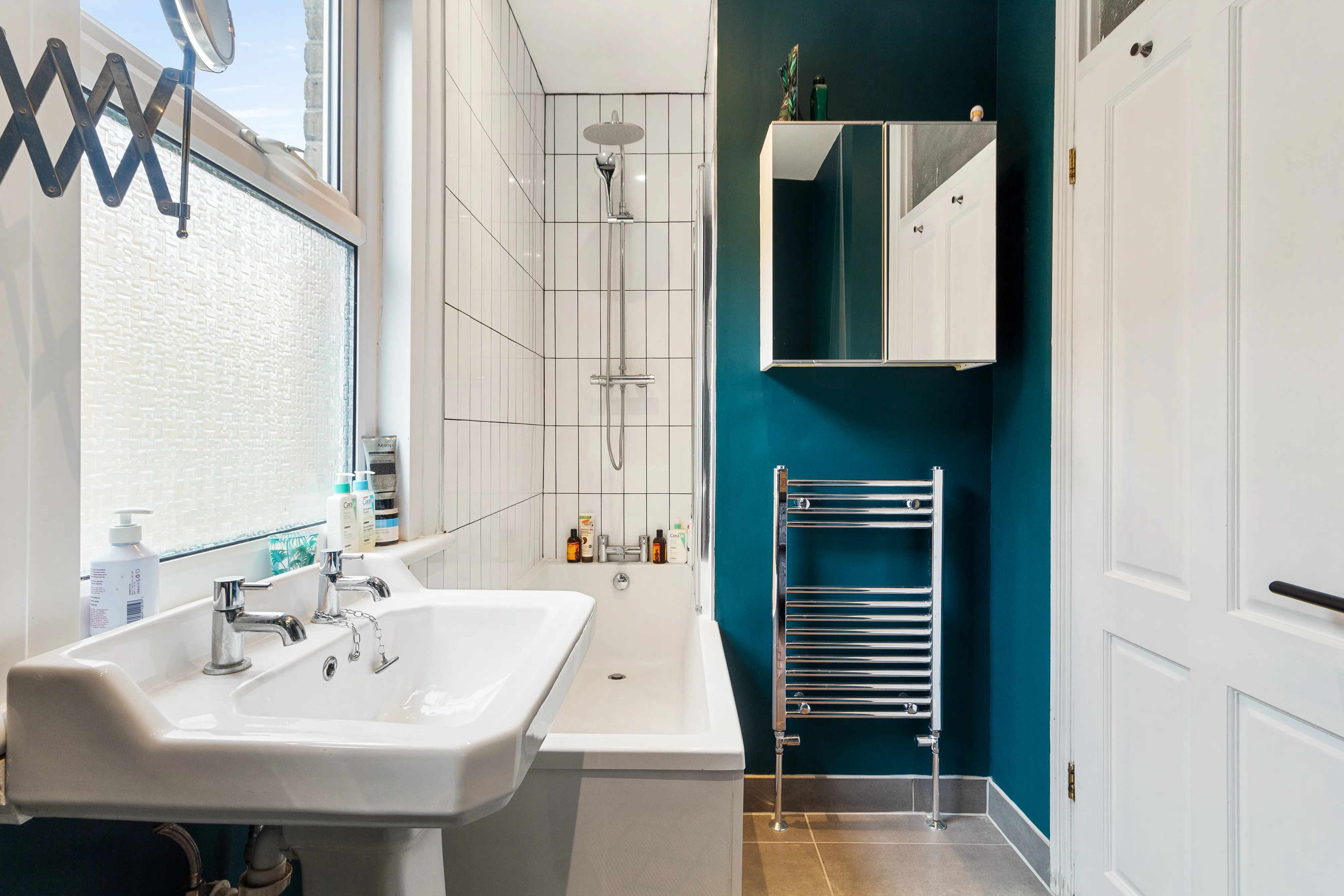 Bathroom with a bath, shower and white tiled walls